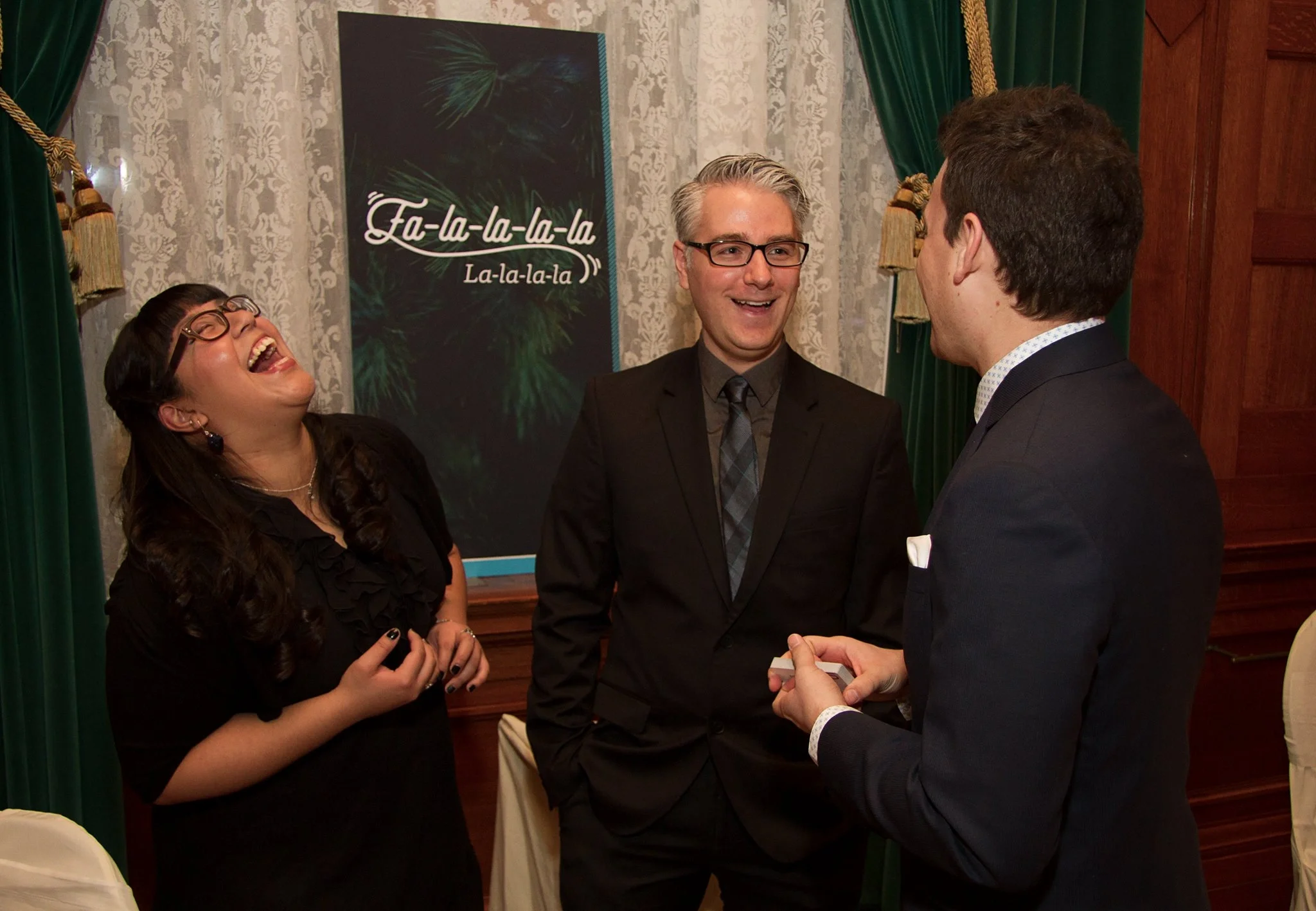 guests laughing with Winnipeg close-up magician Patrick Gregoire at a corporate holiday party