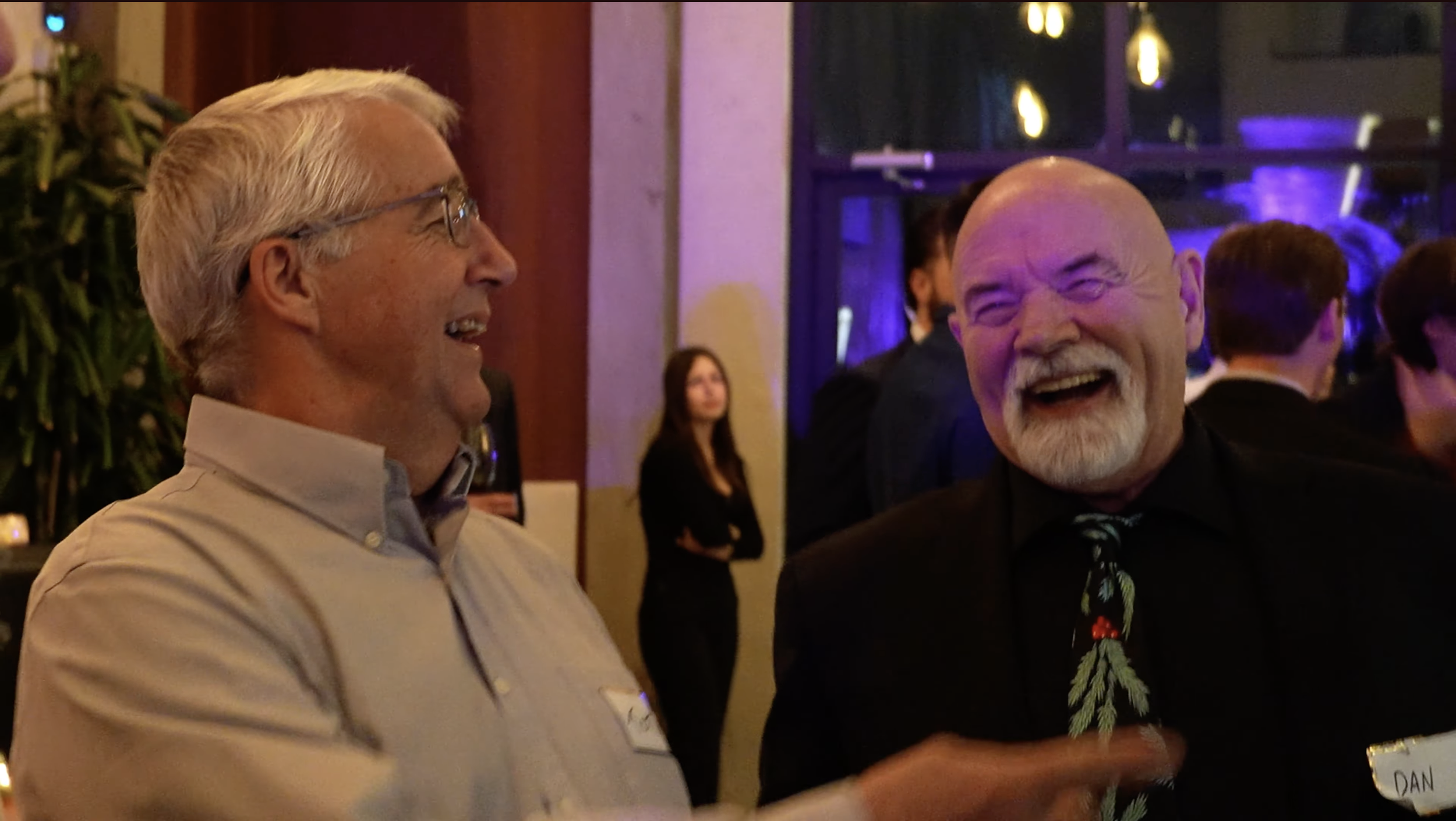Two guests laughing together during Patrick Gregoire's close-up mind reading at a corporate event