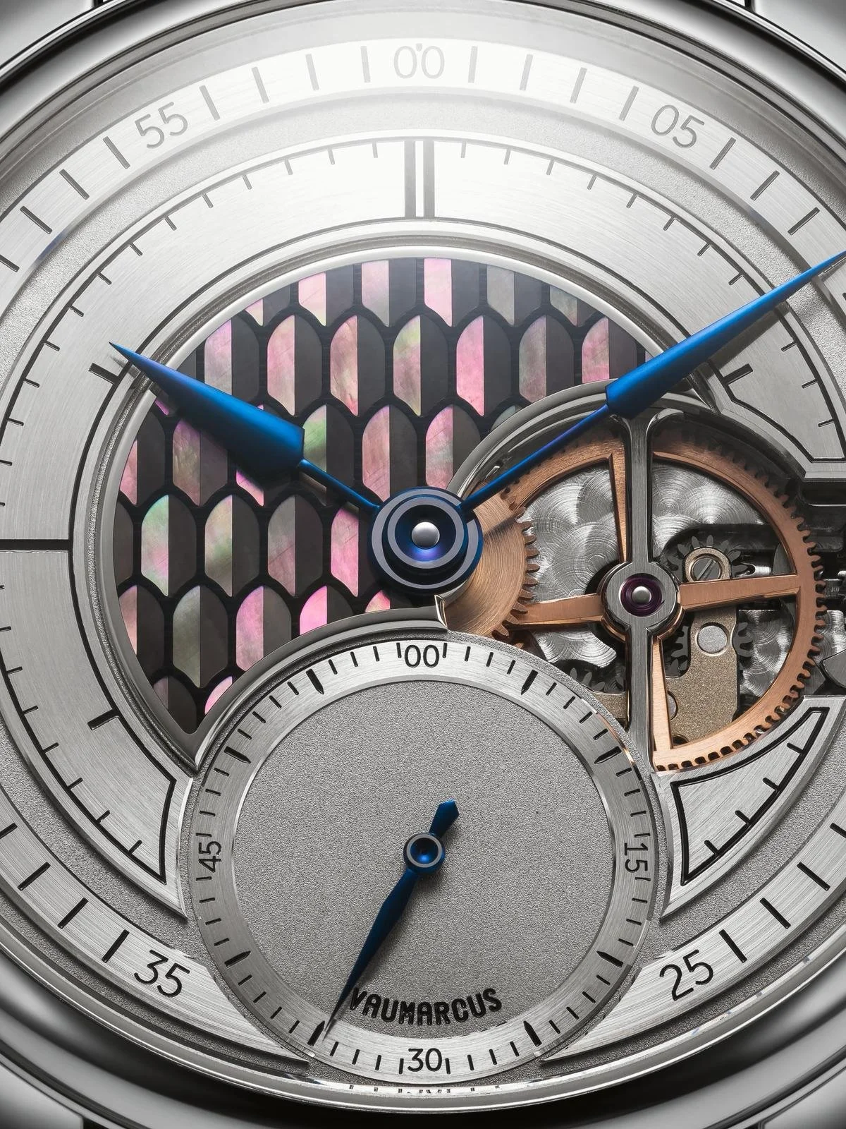 Close-up of a silver wristwatch with the brand name SOPRANA on the dial, featuring blue hour and minute hands, a small seconds subdial at the 6 o'clock position, and a black leather strap.
