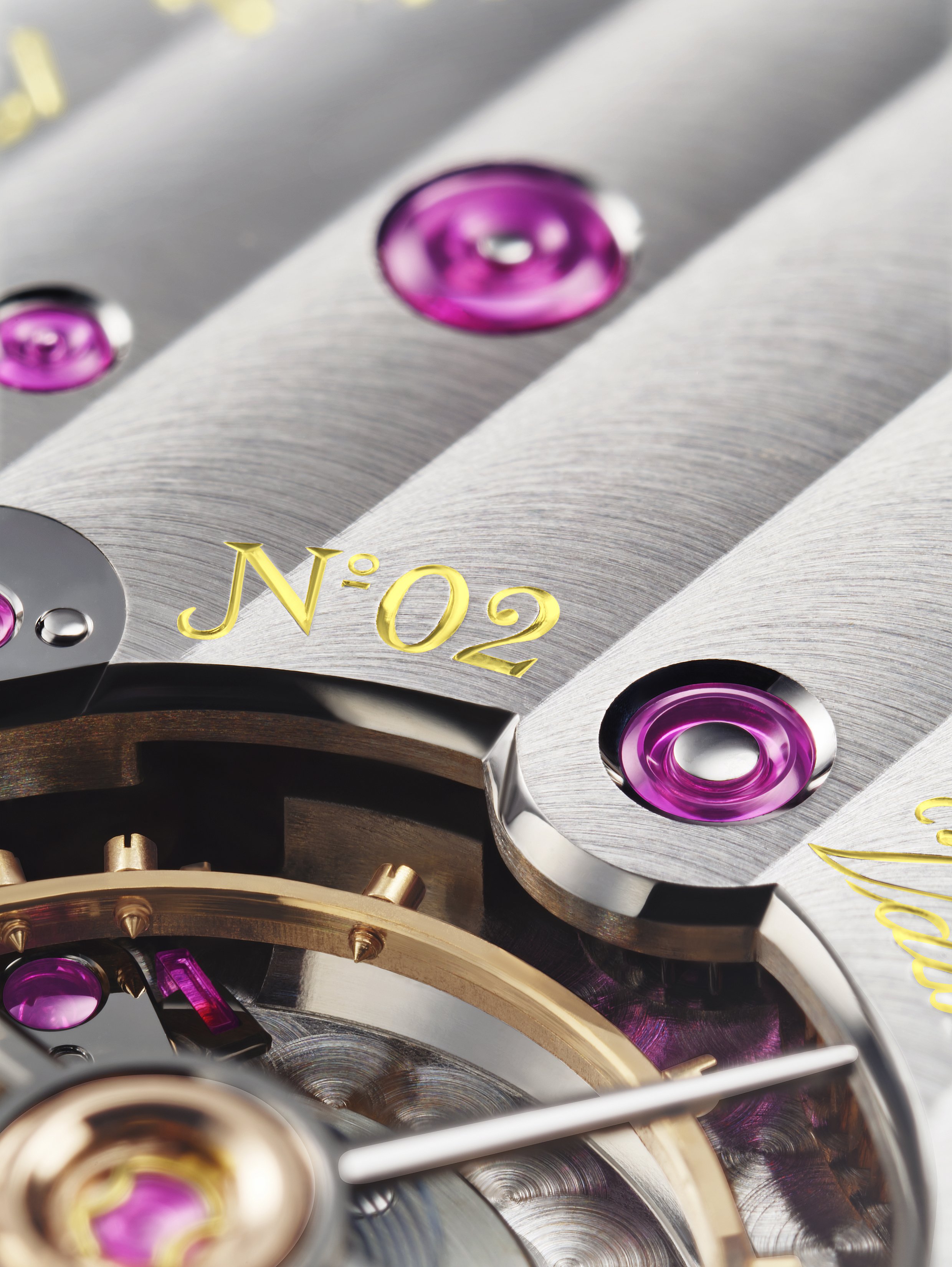 Close-up of a watch movement showing polished screws, gold numbers, and intricate mechanical parts.