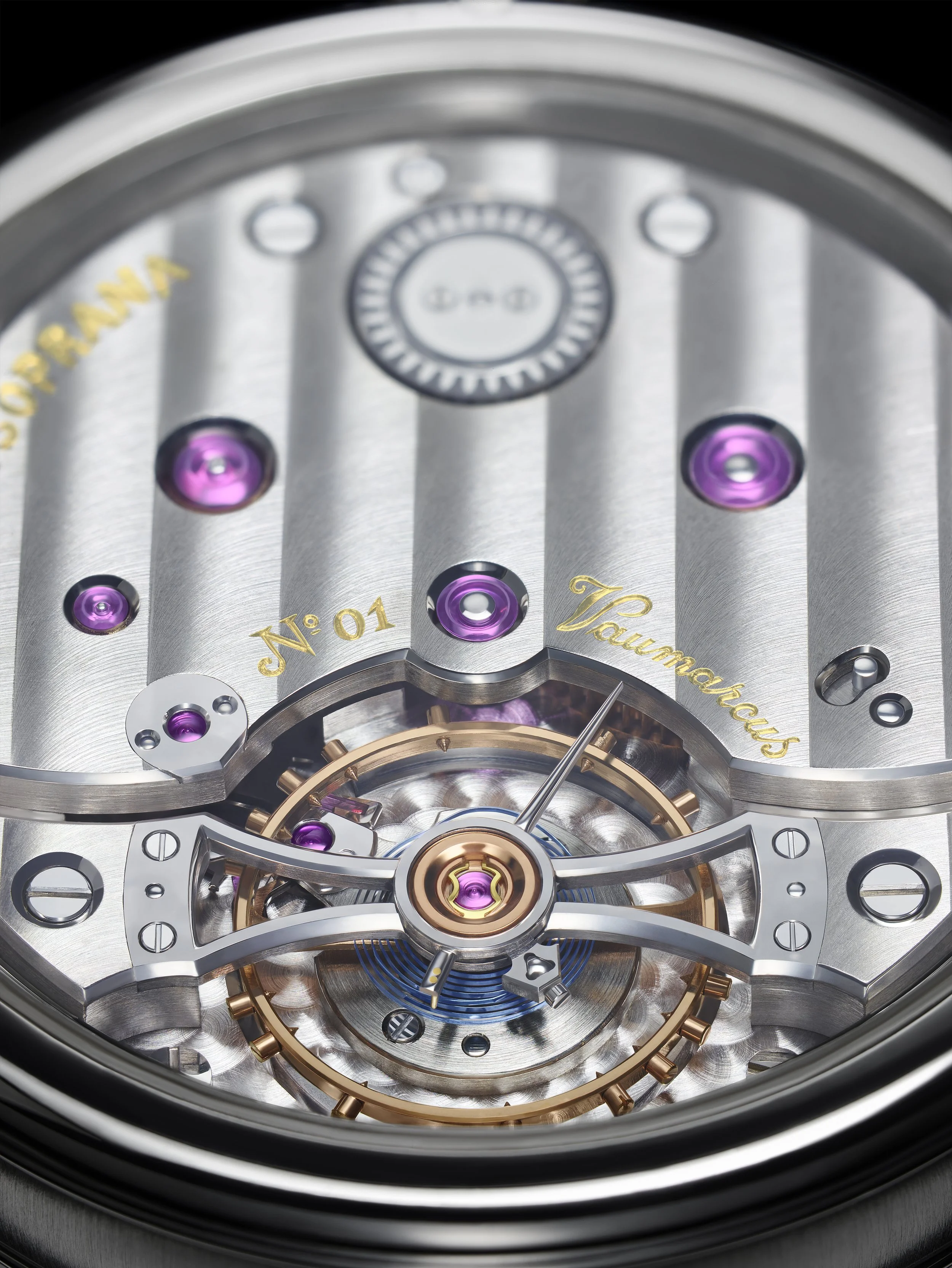 Close-up of a luxury watch movement showing gears, purple jewels, and intricate metal components with gold inscriptions.