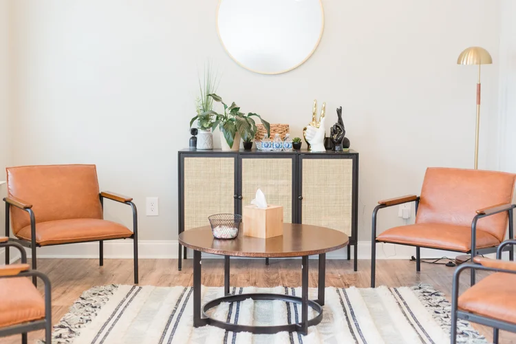 A therapy office with warm orange chairs and soft natural light