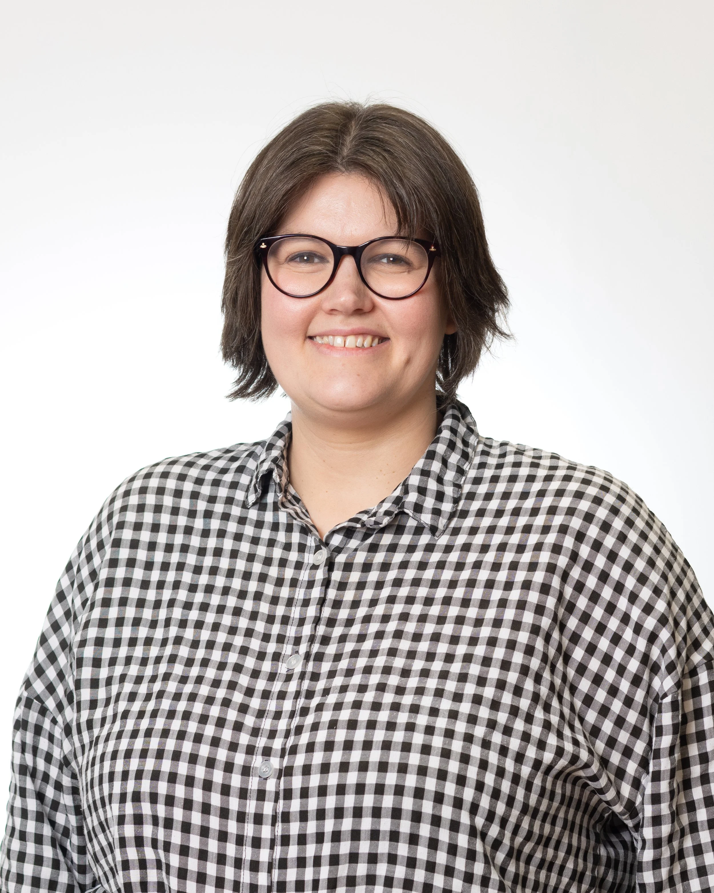 A woman with glasses wearing a stripey shirt.