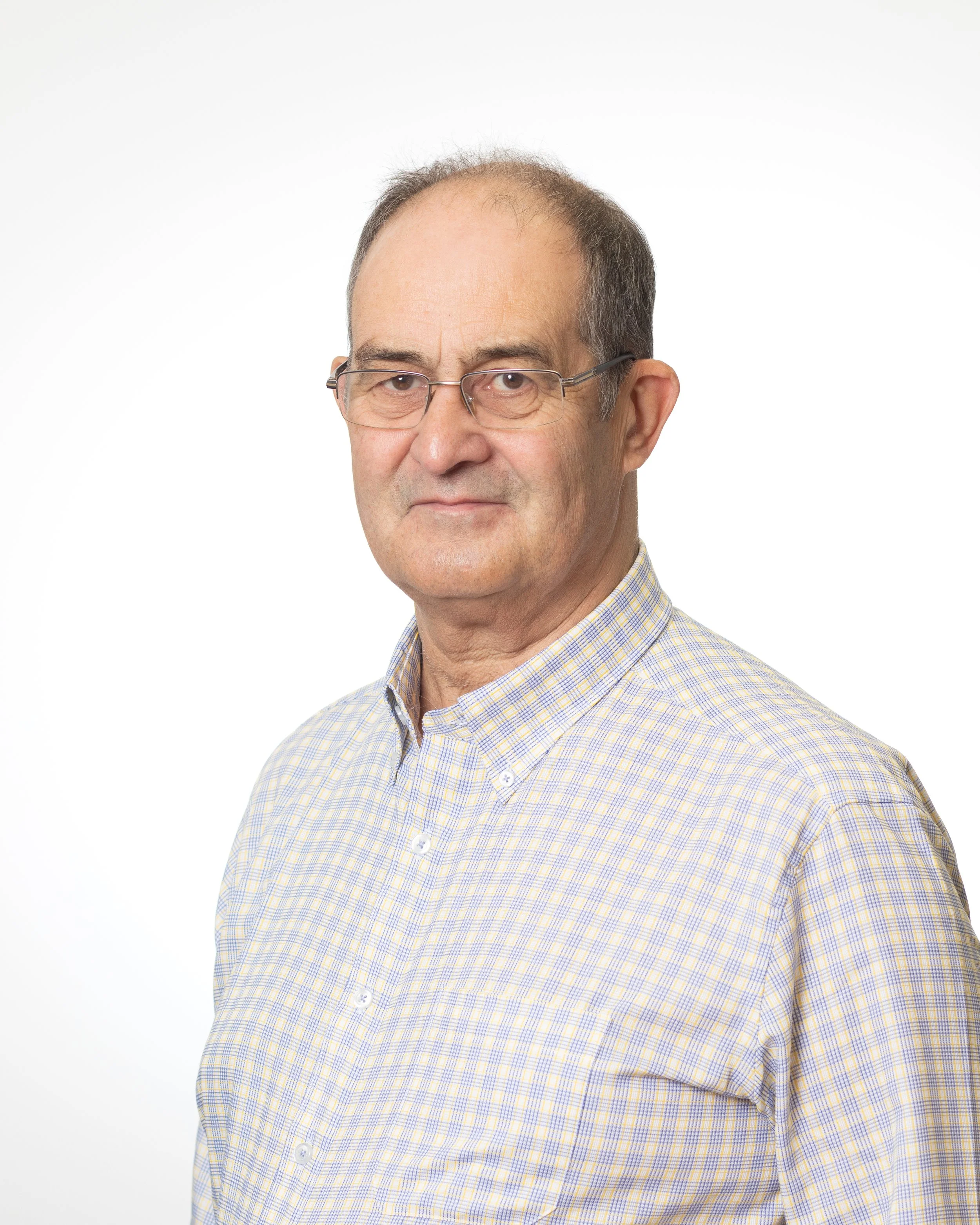 A middle aged man in a white shirt and wearing glasses