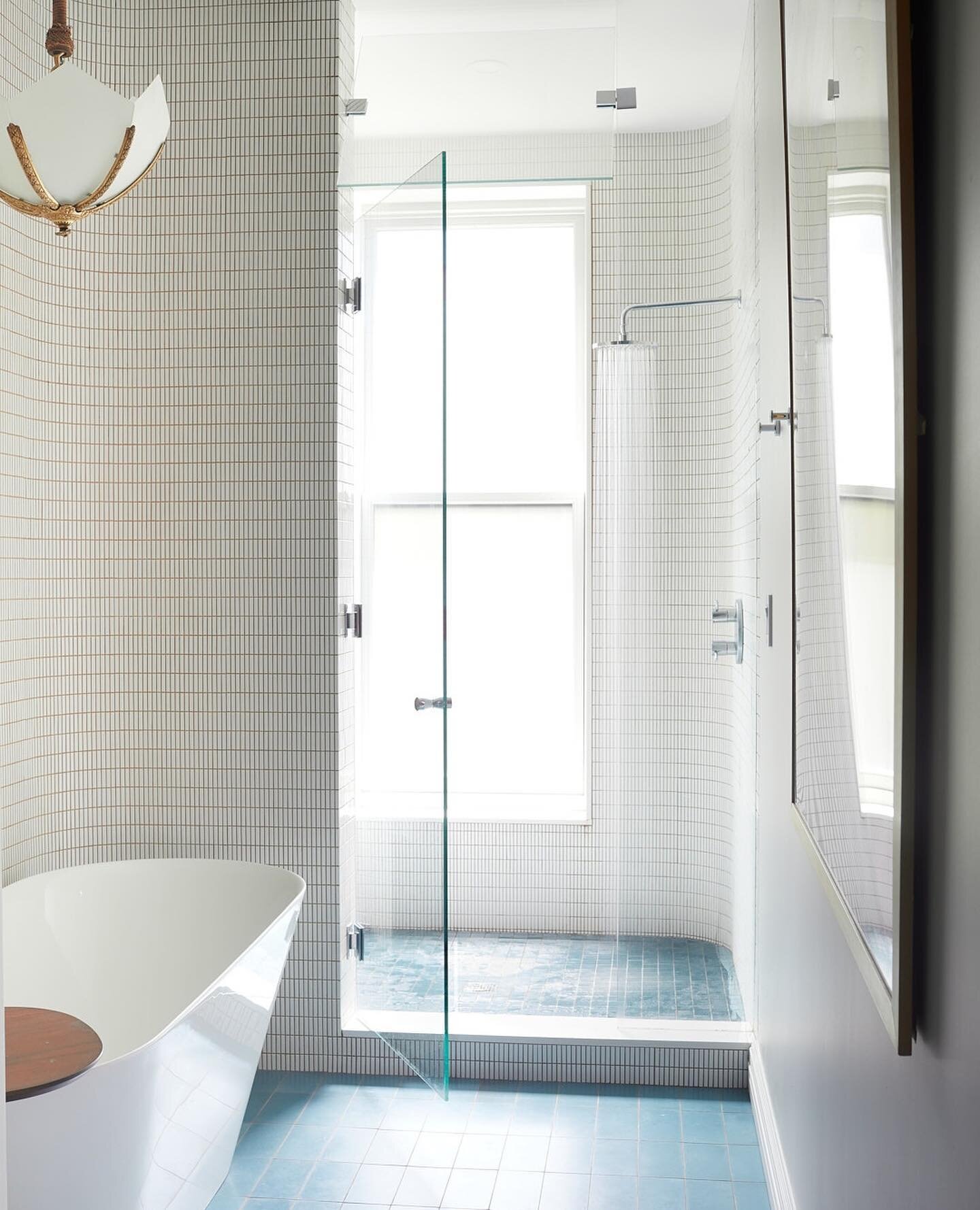 This primary Bathroom in our Park Slope Triplex Townhouse Project had a long narrow fooprint.  To utilize the length, we located the shower at the window side and a toilet room at the other end.  We nestled the soaking tub in a curved tiled niche in 