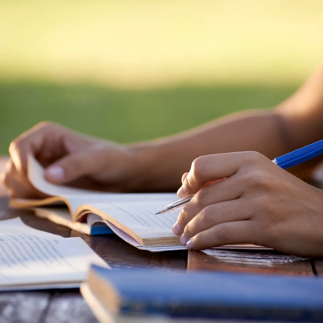 Image of person's hands looking over books and papers