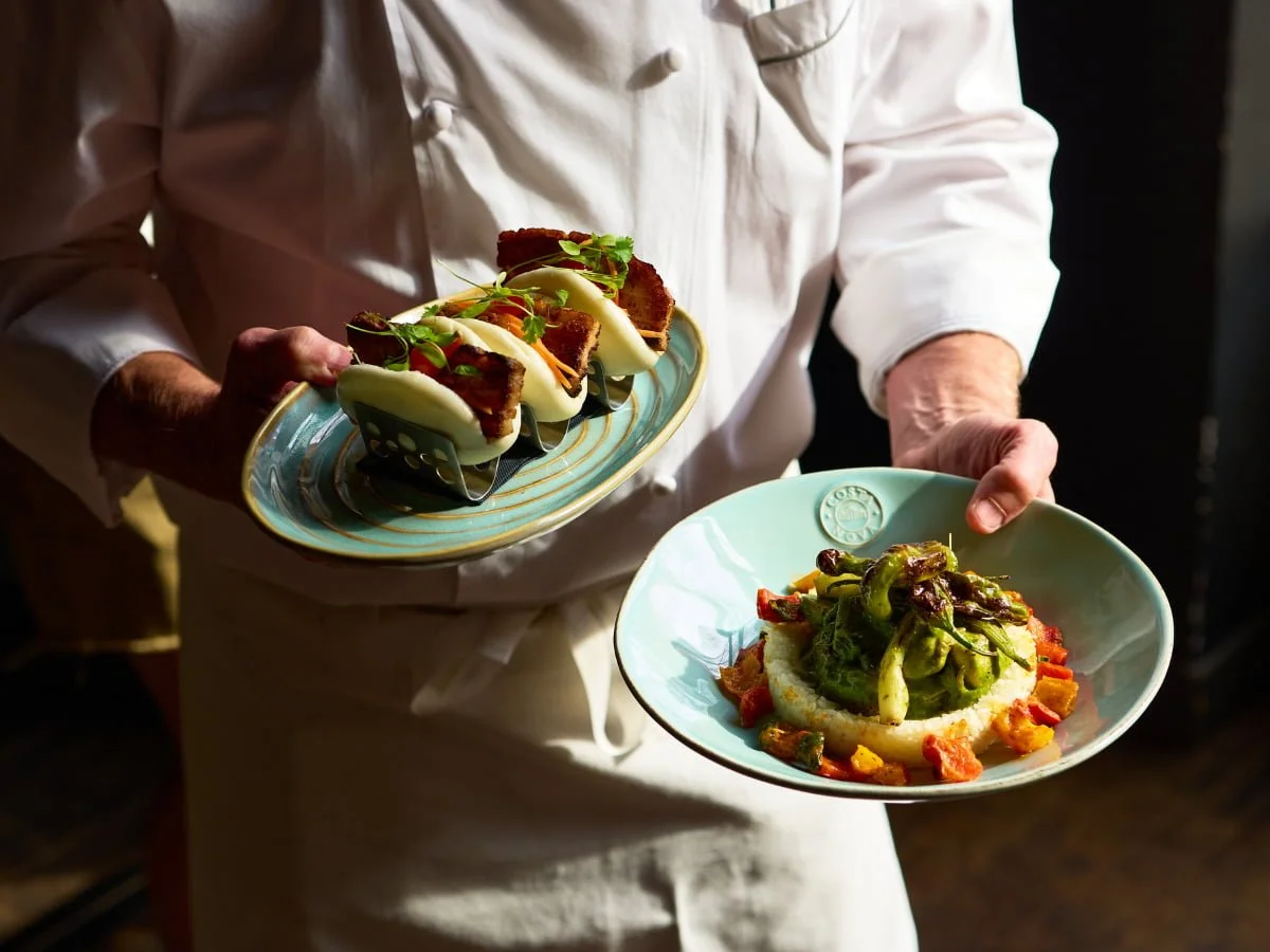 Chef Doherty holding BLACKBARN's Heritage Chicken Fricasse and Pork Belly Bao
