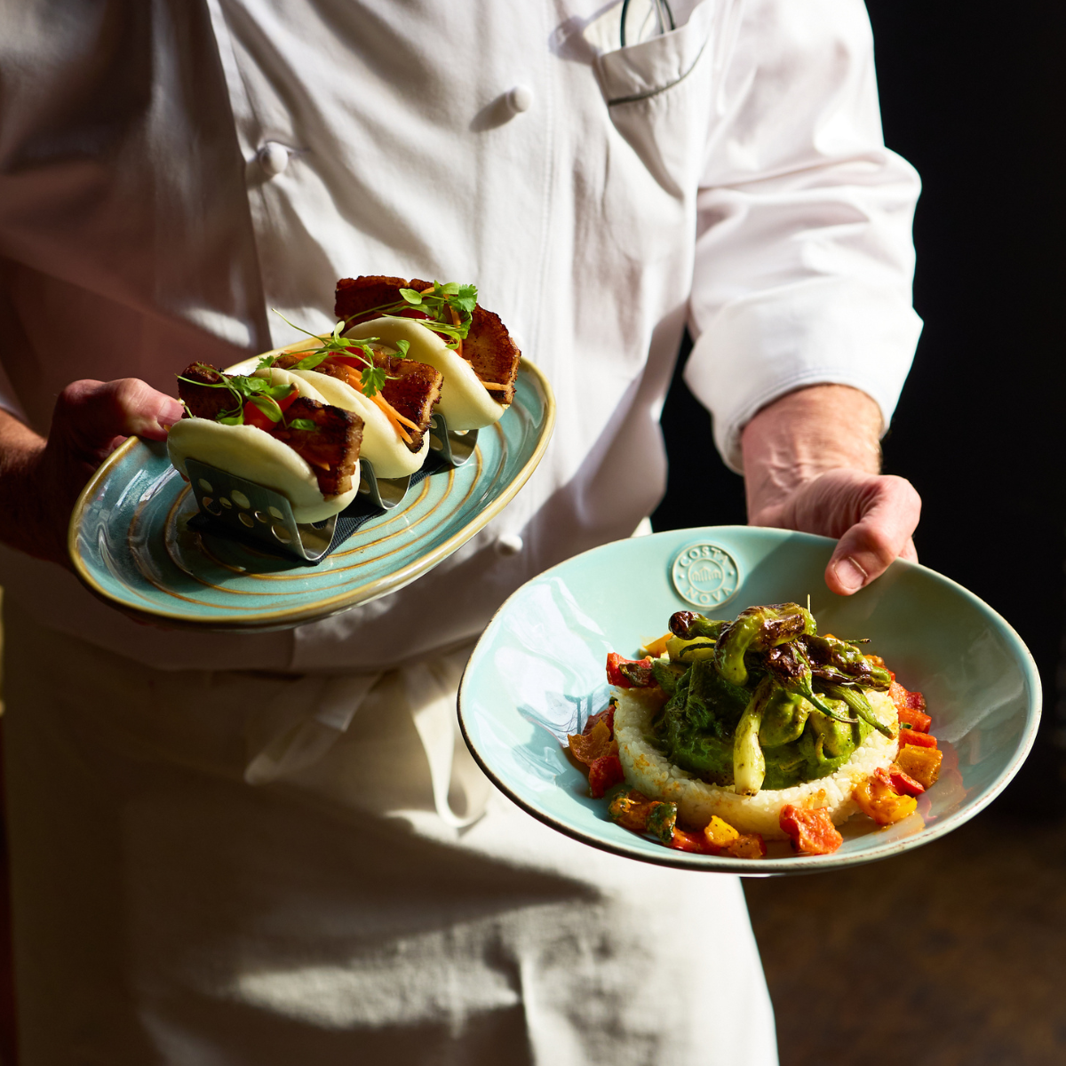 Chef John Holding Pork Belly Bao Buns and Heritage Chicken Fricassee Summer Restaurant Week 2026.png