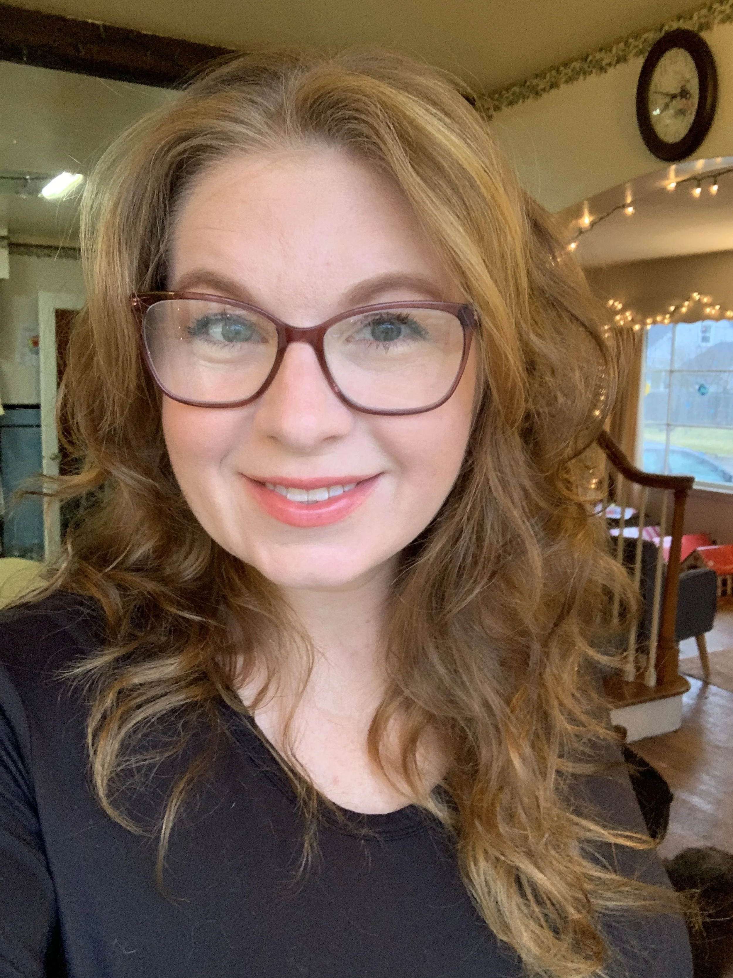 smiling woman with red hair and large glasses