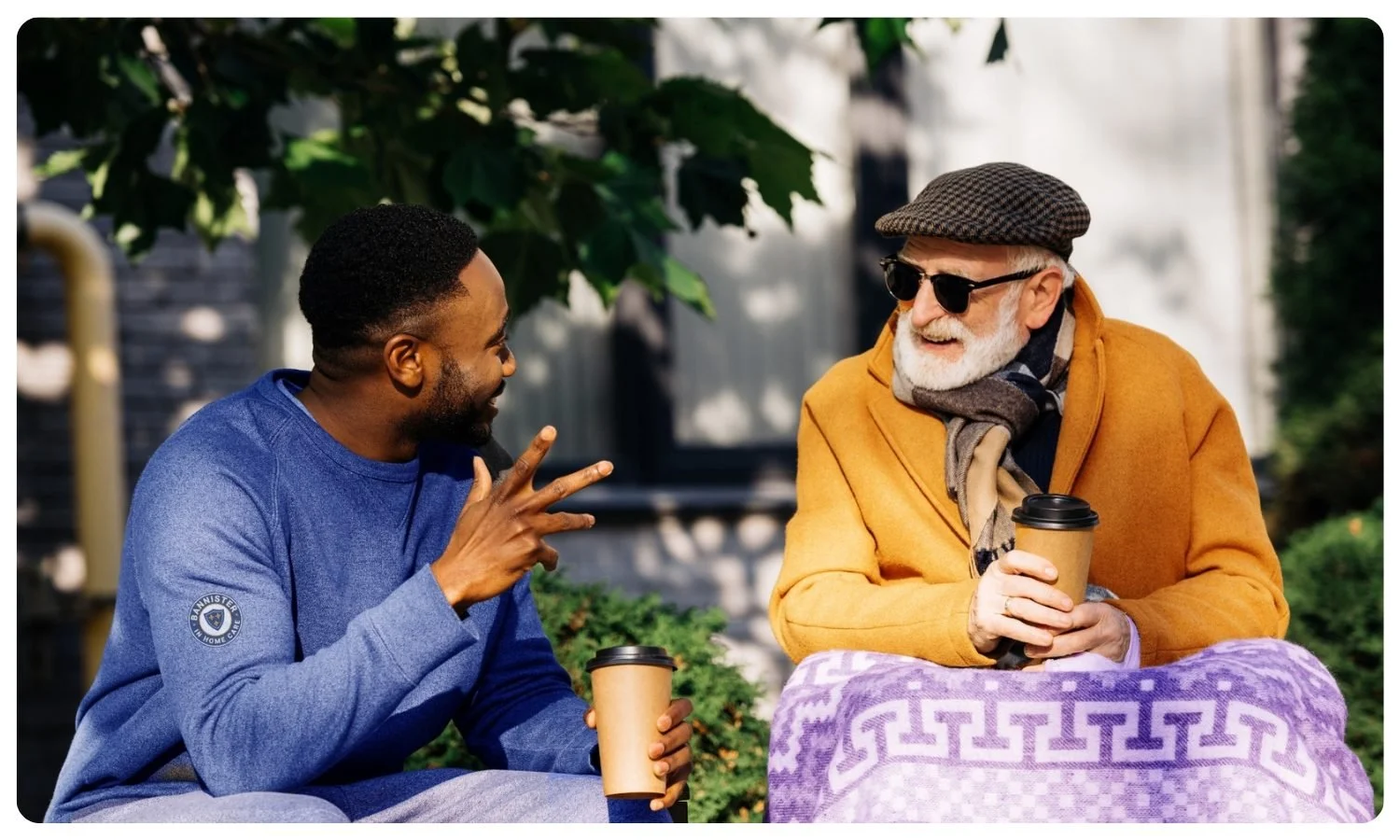 local male support worker chats outside with his elderly male client, social support for elderly, friends for older people,  connecting isolated elderly with providers