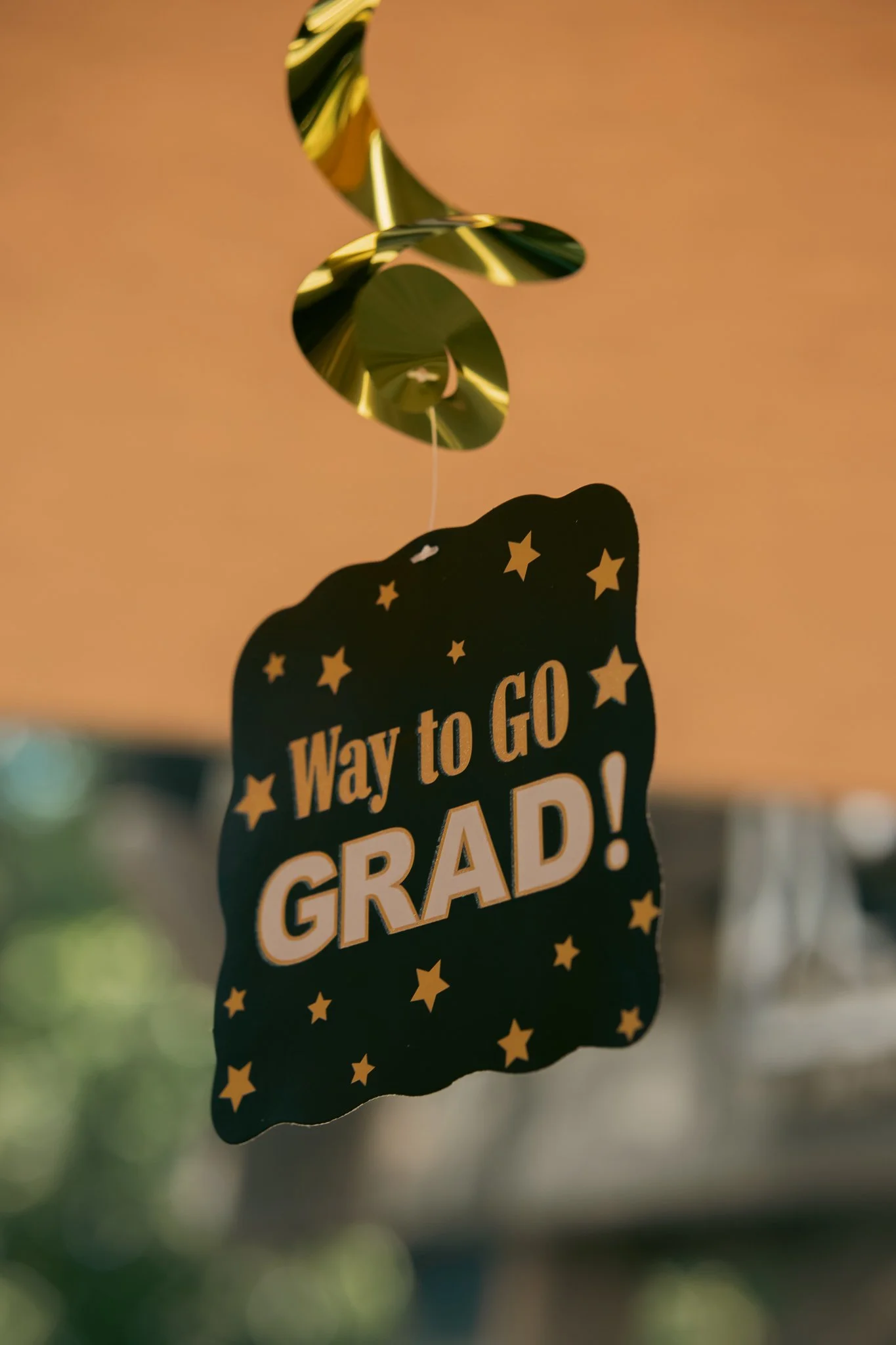 Hanging graduation decoration with "Way to Go Grad!" and gold stars.