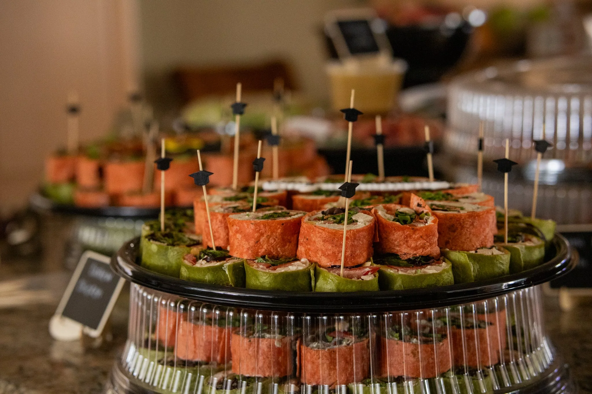Close-up of colorful wrap sandwiches on a platter with cocktail toothpicks.