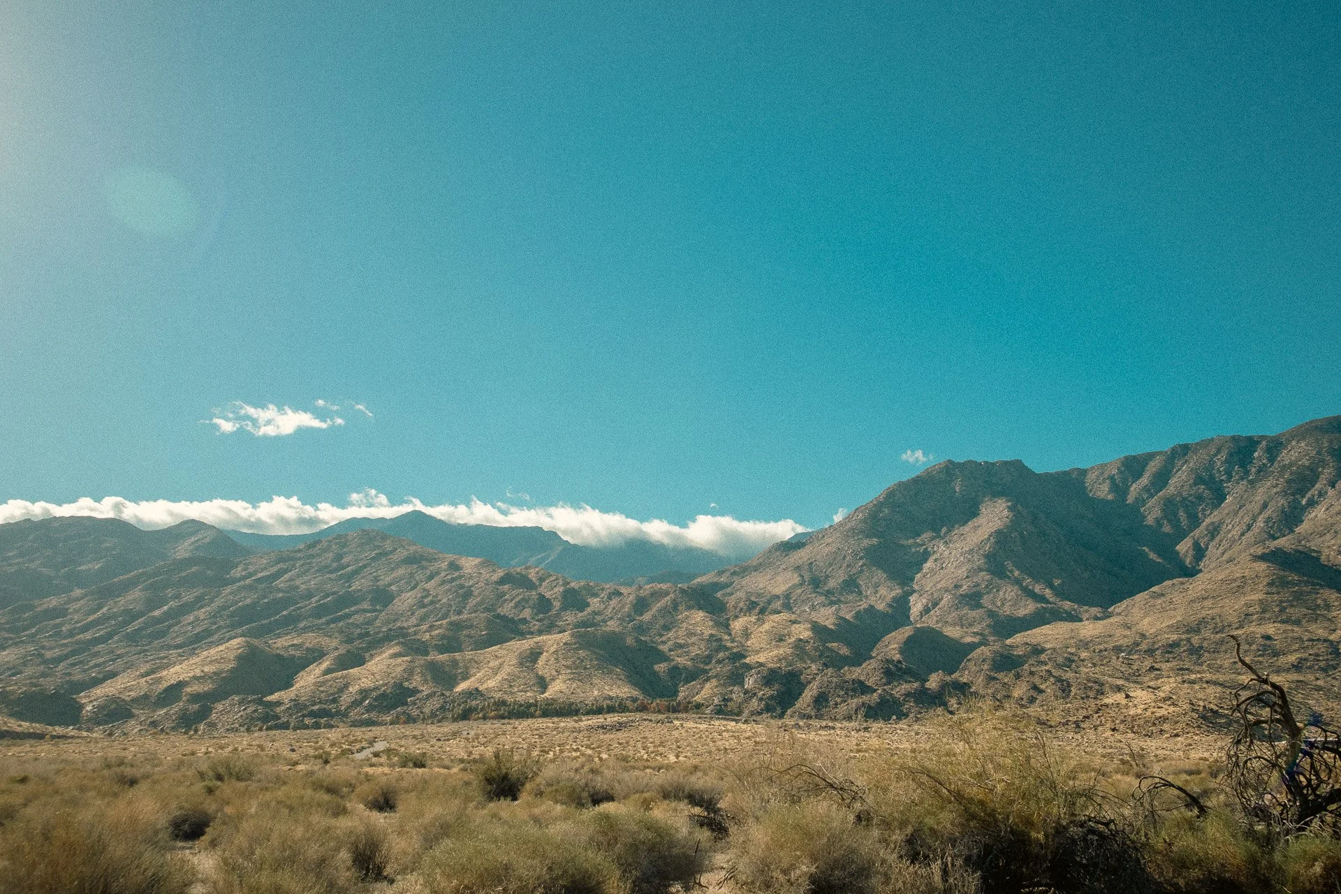 Desert landscape with mountains and blue sky.
