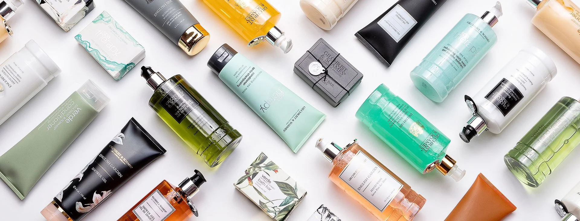 Assorted skincare and beauty products, including gels, creams, bottles, and soap bars, arranged on a white surface.
