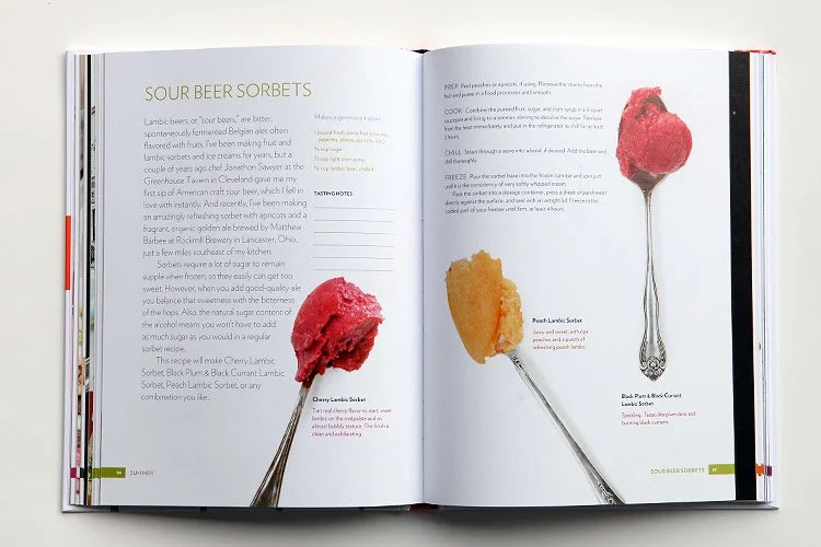 Open cookbook displaying recipes for sour beer sorbets, featuring colorful sorbet scoops on silver spoons, including cherry lambic, peach lambic, and rosé lambic flavors.