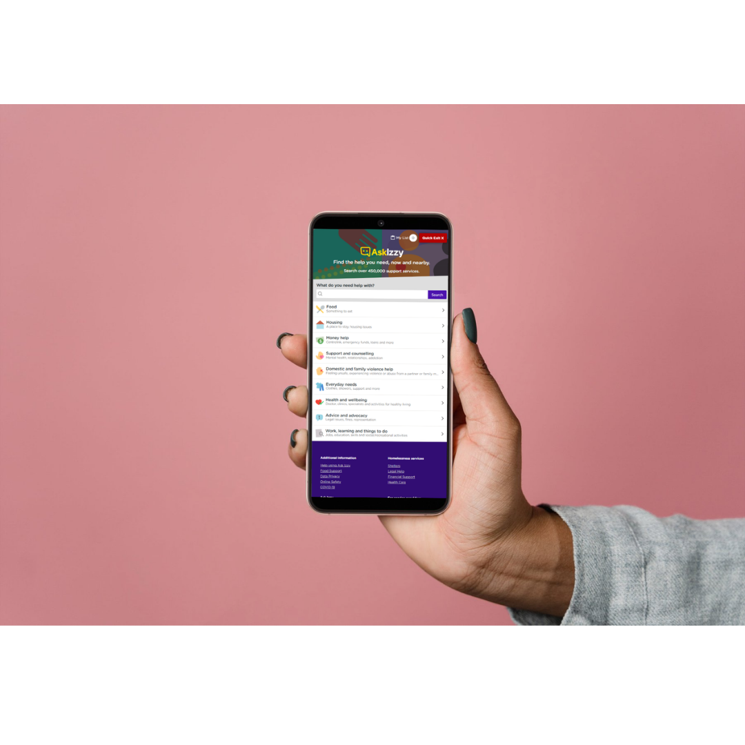 Hand holding smartphone displaying an app called Ask Izzy against a pink background.