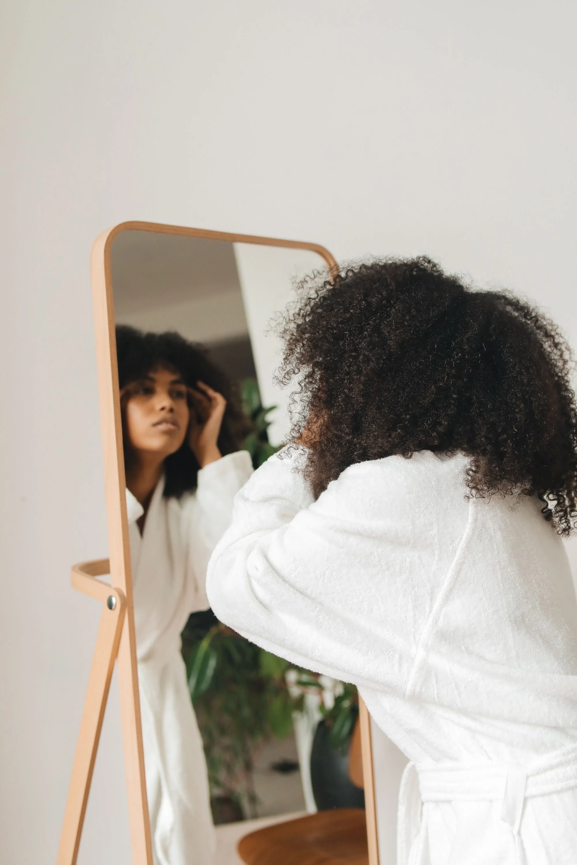 Woman scrutinizing over her reflection in a mirror, representing common concerns addressed in ACT therapy in North Riverside, IL