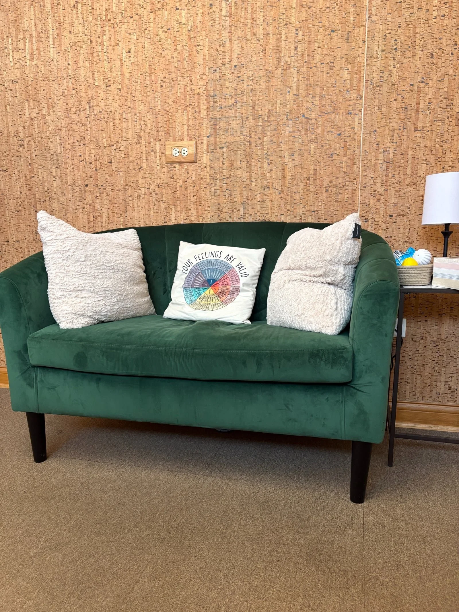 Green couch and side table with lamp inside of Patrick Rossi's office