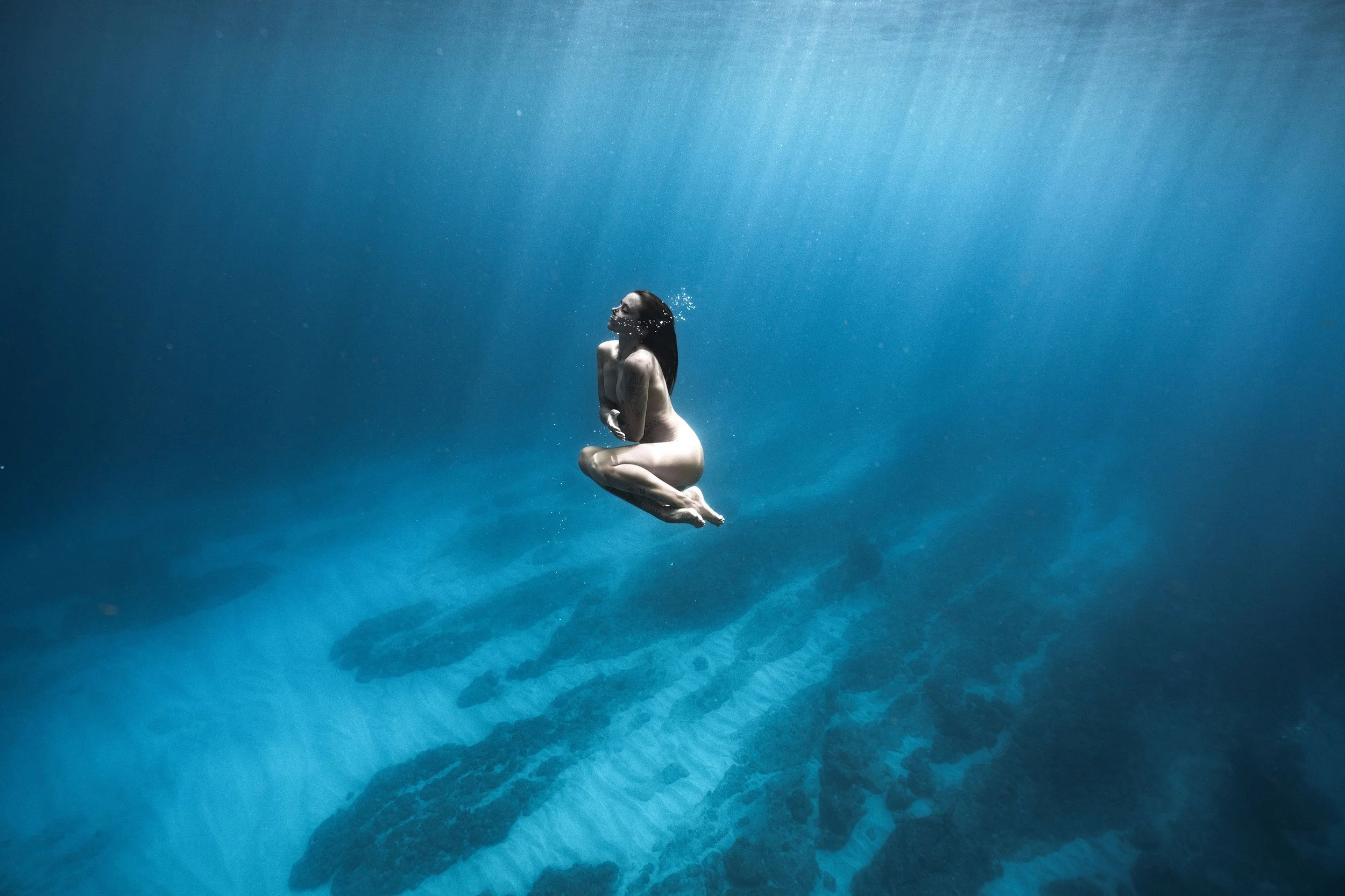 une femme qui flotte dans l'eau bleu qui s'enlqce