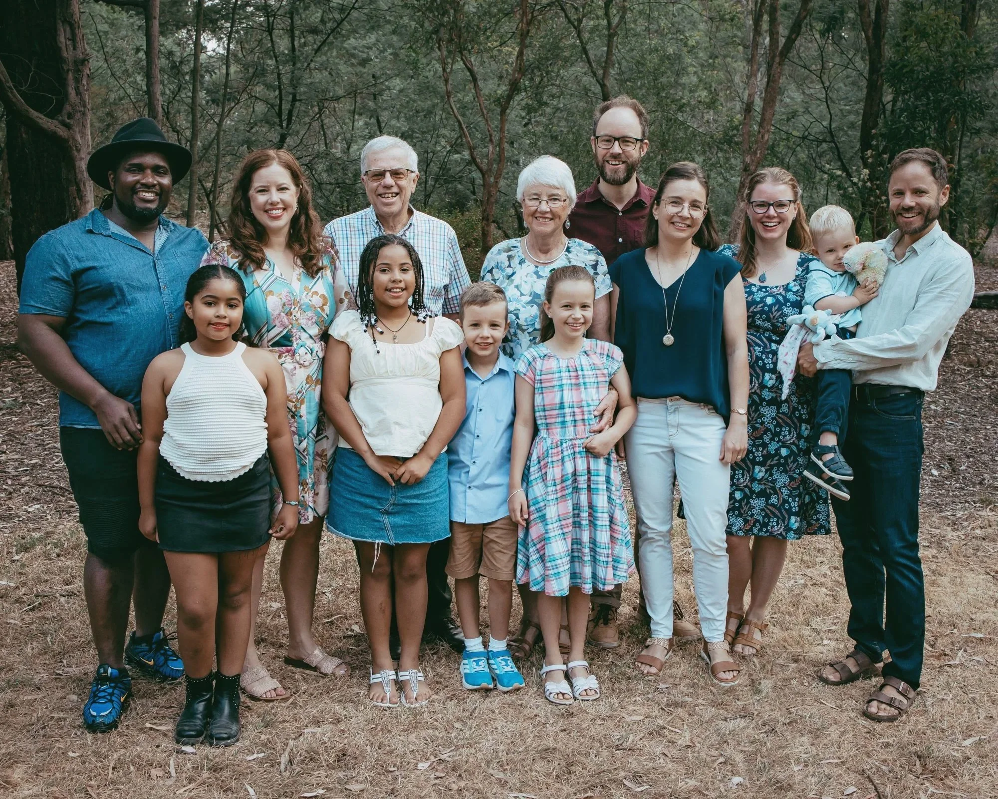 Extended family smile in parkland, during a photo session in Blackburn