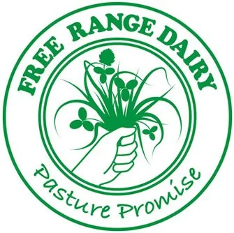 Logo for Free Range Dairy featuring a hand holding a sprig of clover and grass, with green text on a circular white background.