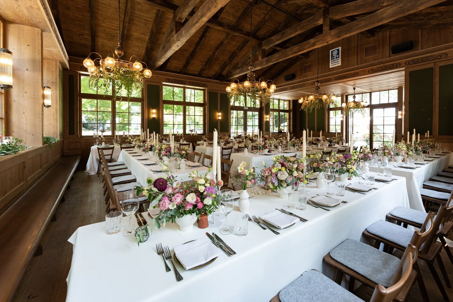 Rustikaler Saal mit Holzbalken und langer Tafel