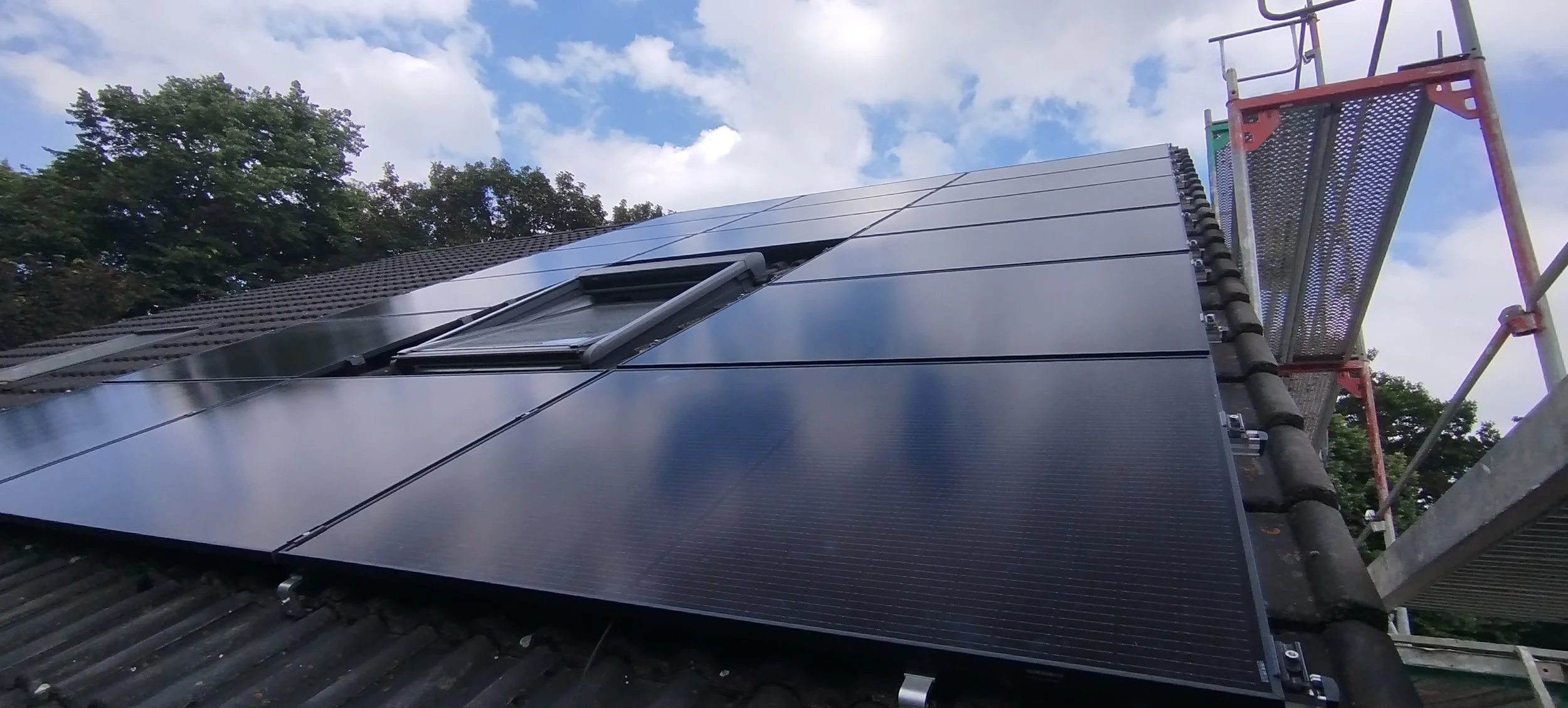 Solarpanels auf einem Hausdach mit Blick nach oben gegen den Himmel mit Wolken. Solar NRW GmbH.