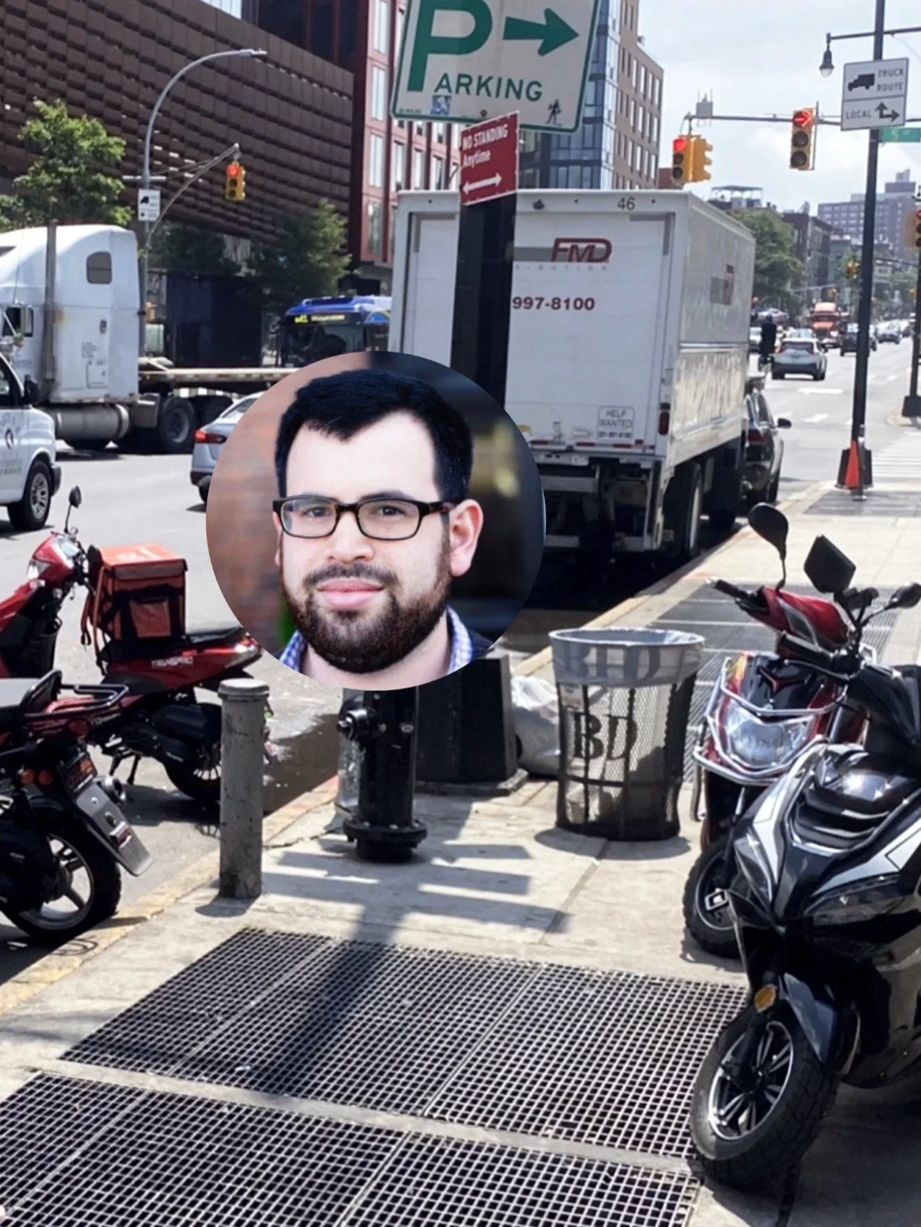 City street scene with parked motorcycles and a delivery truck. There is a photo of a man with glasses and a beard overlayed on the image.