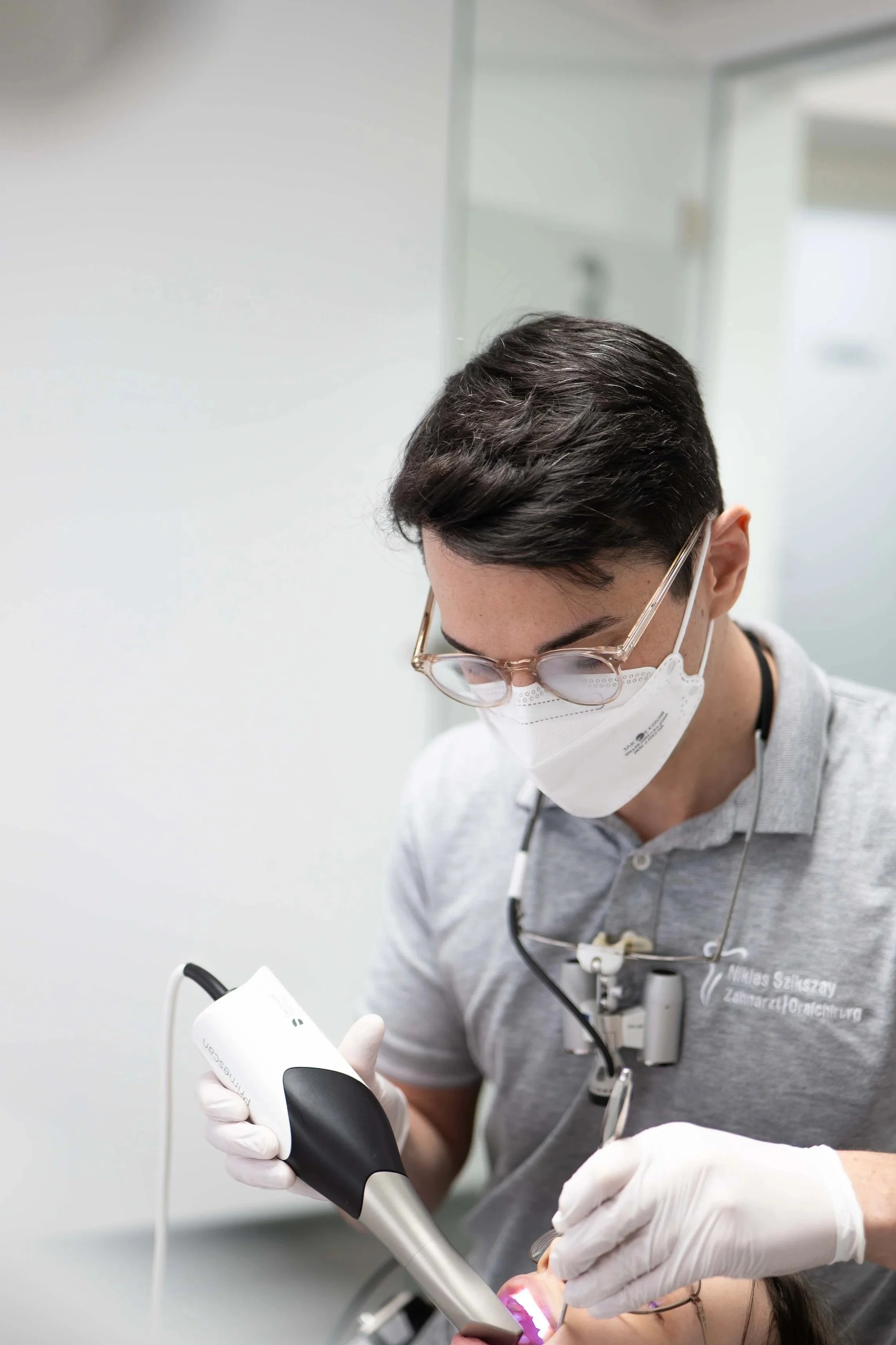 Zahnarzt arbeitet mit Dentalgerät an Patient im Behandlungsraum.