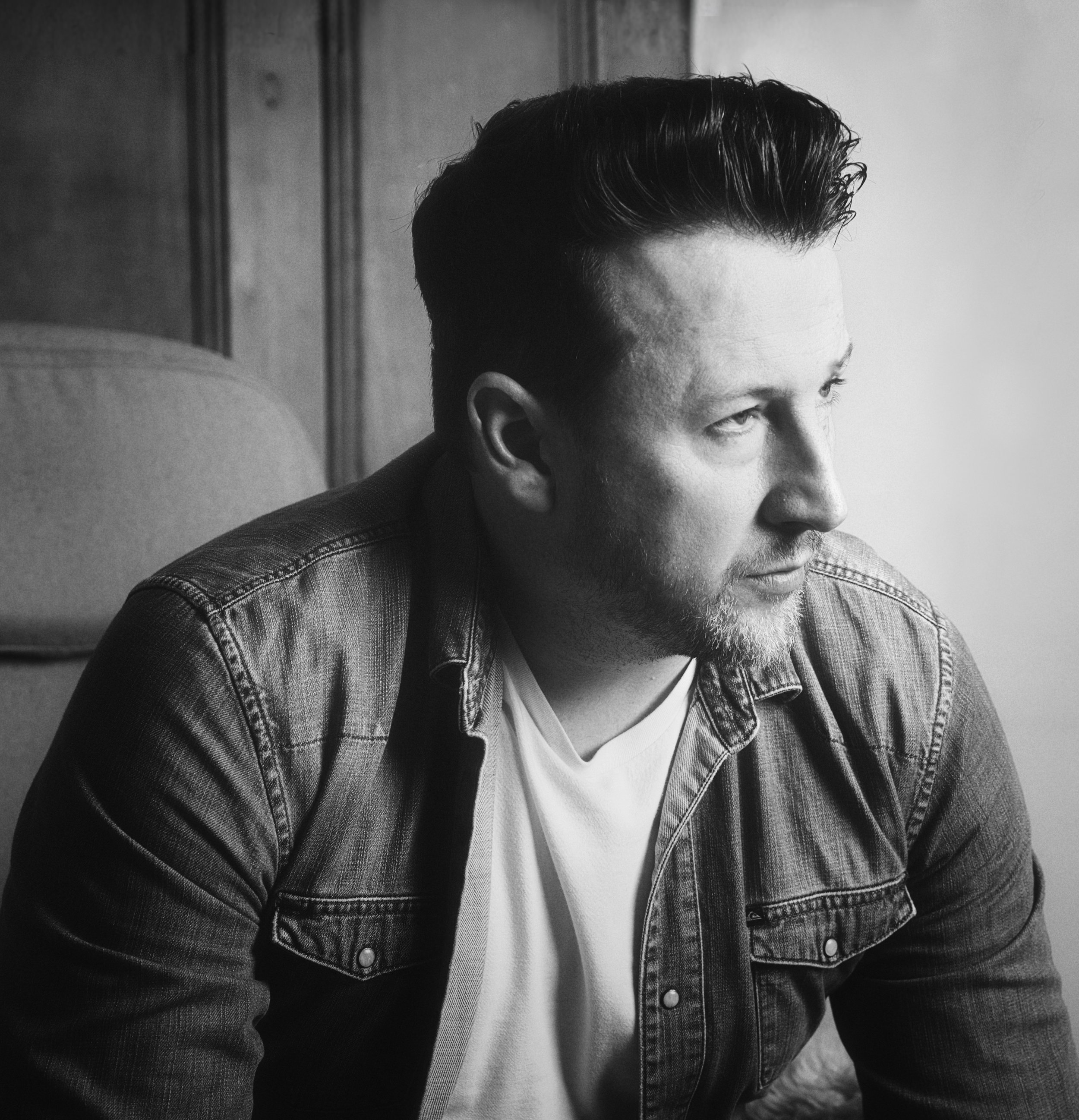 Black and white portrait of photographer Reid Williams in soft window light