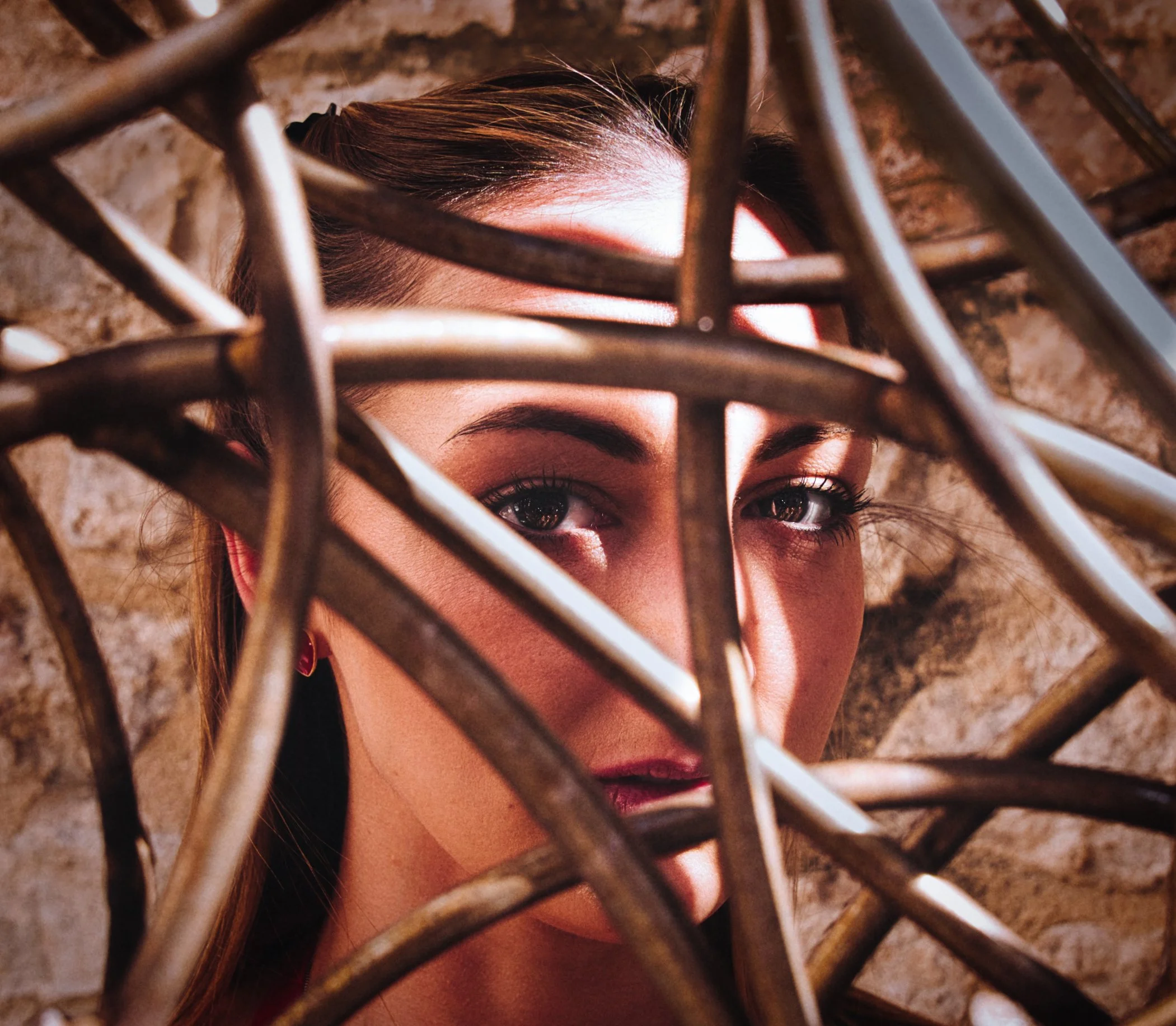 Creative portrait framed through an ornate metal gate