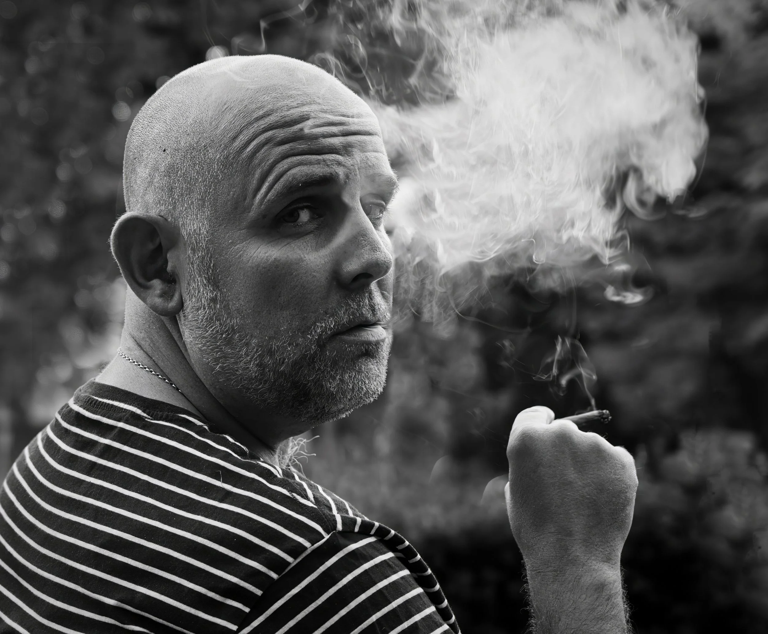 Black and white portrait of a man smoking outdoors