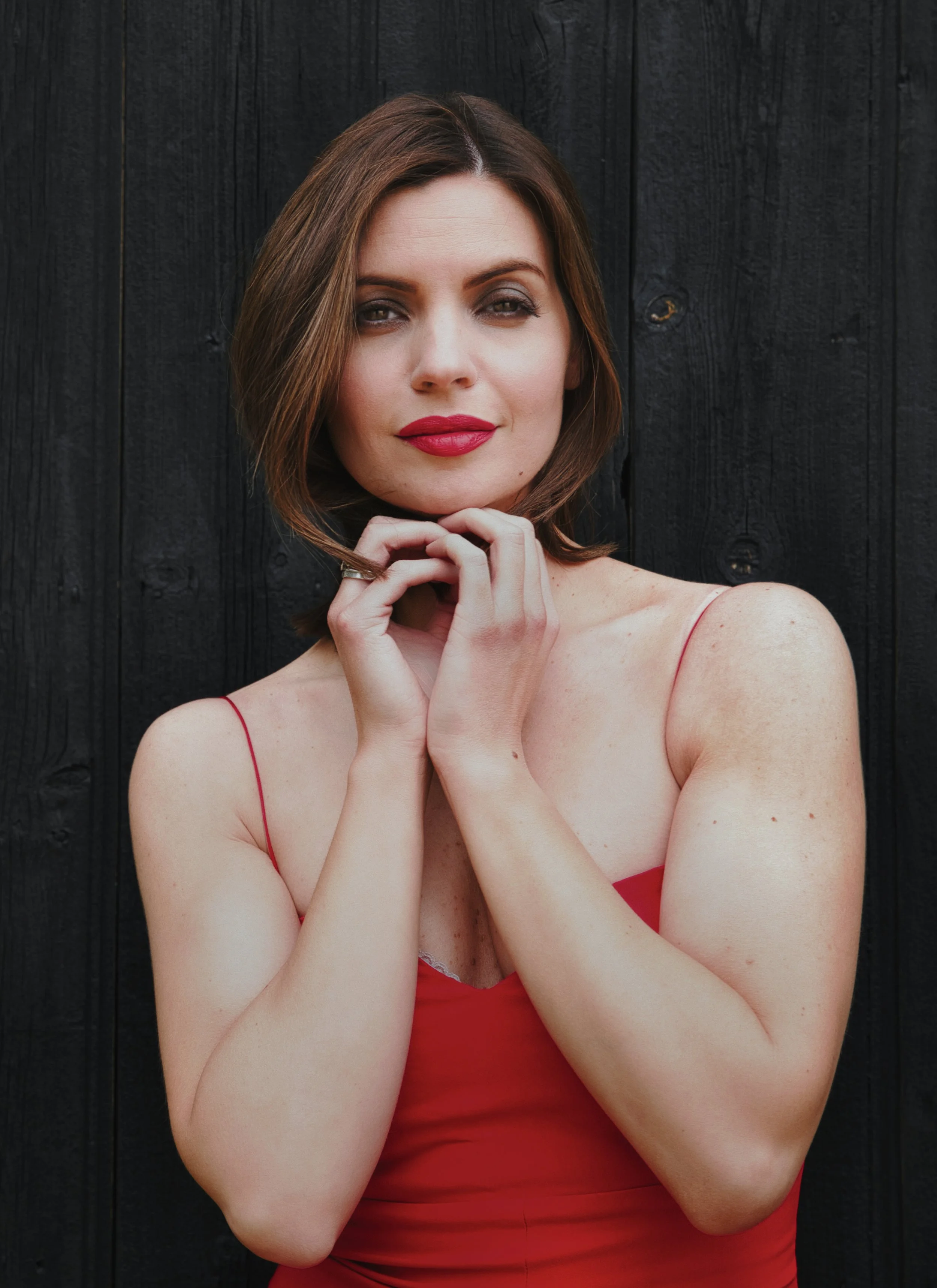 Portrait of a woman in a red dress against a dark background
