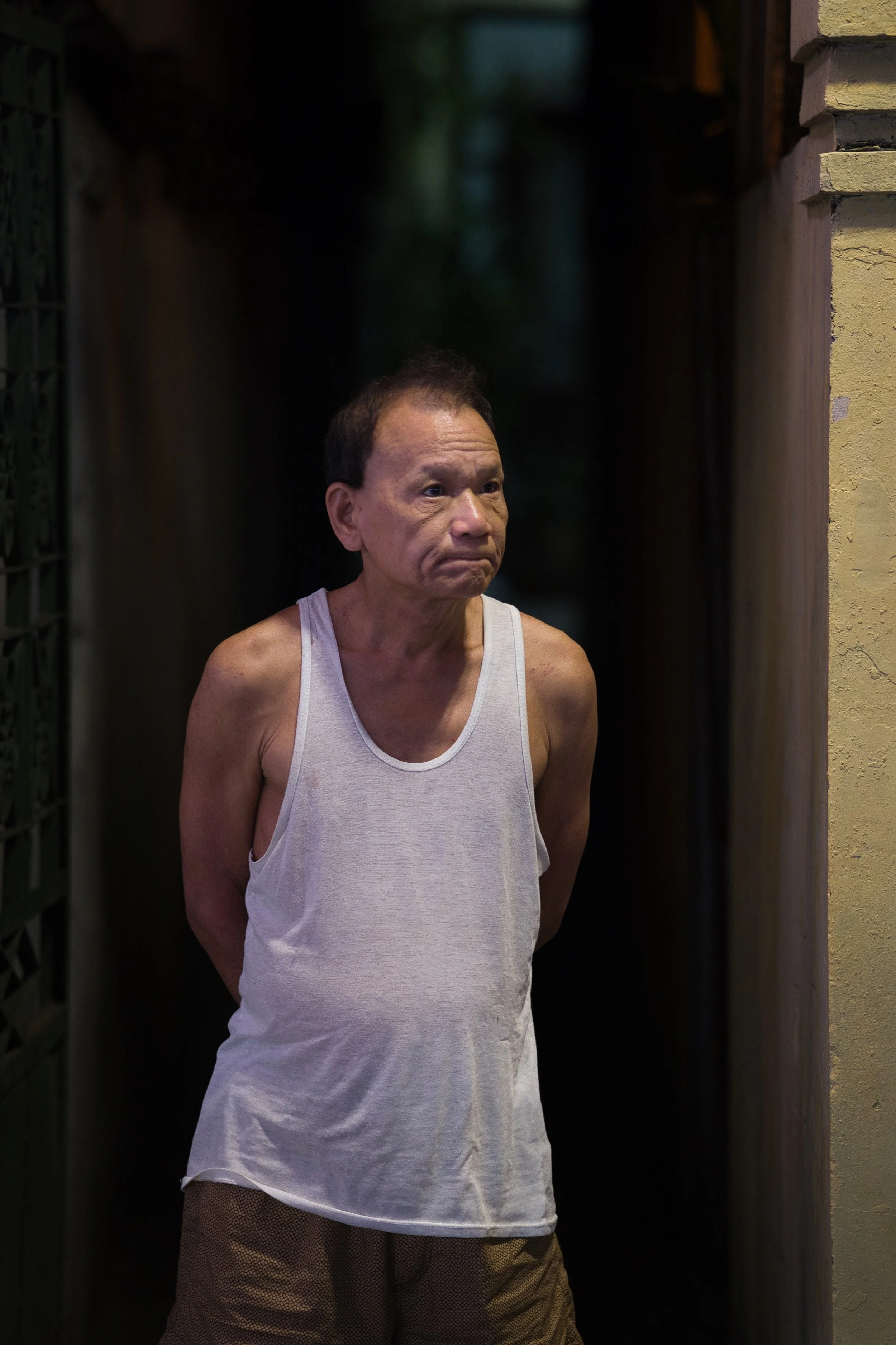 Portrait of a man standing in a dimly lit alleyway in Ho Chi Minh City