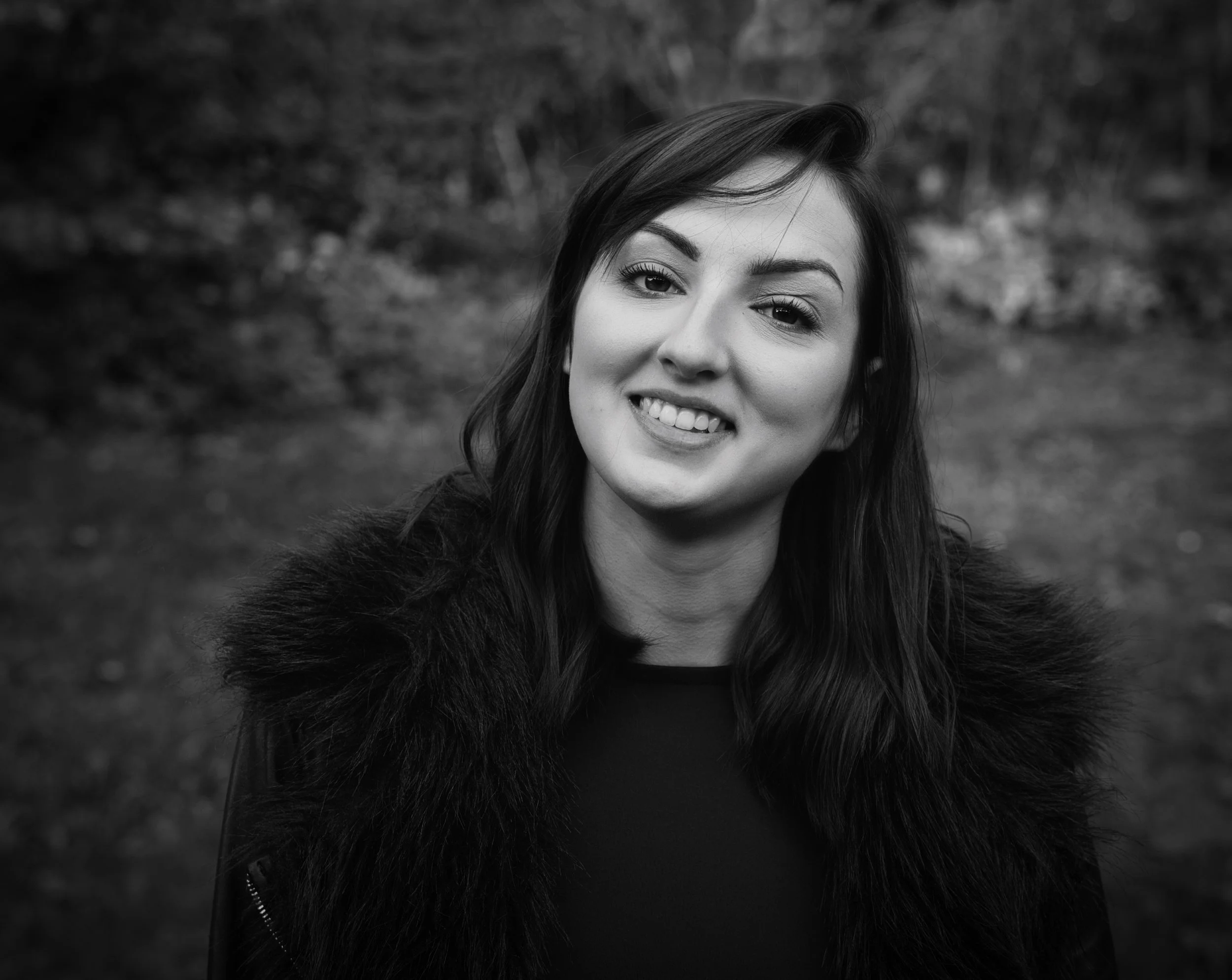 Black and white outdoor portrait of a smiling woman