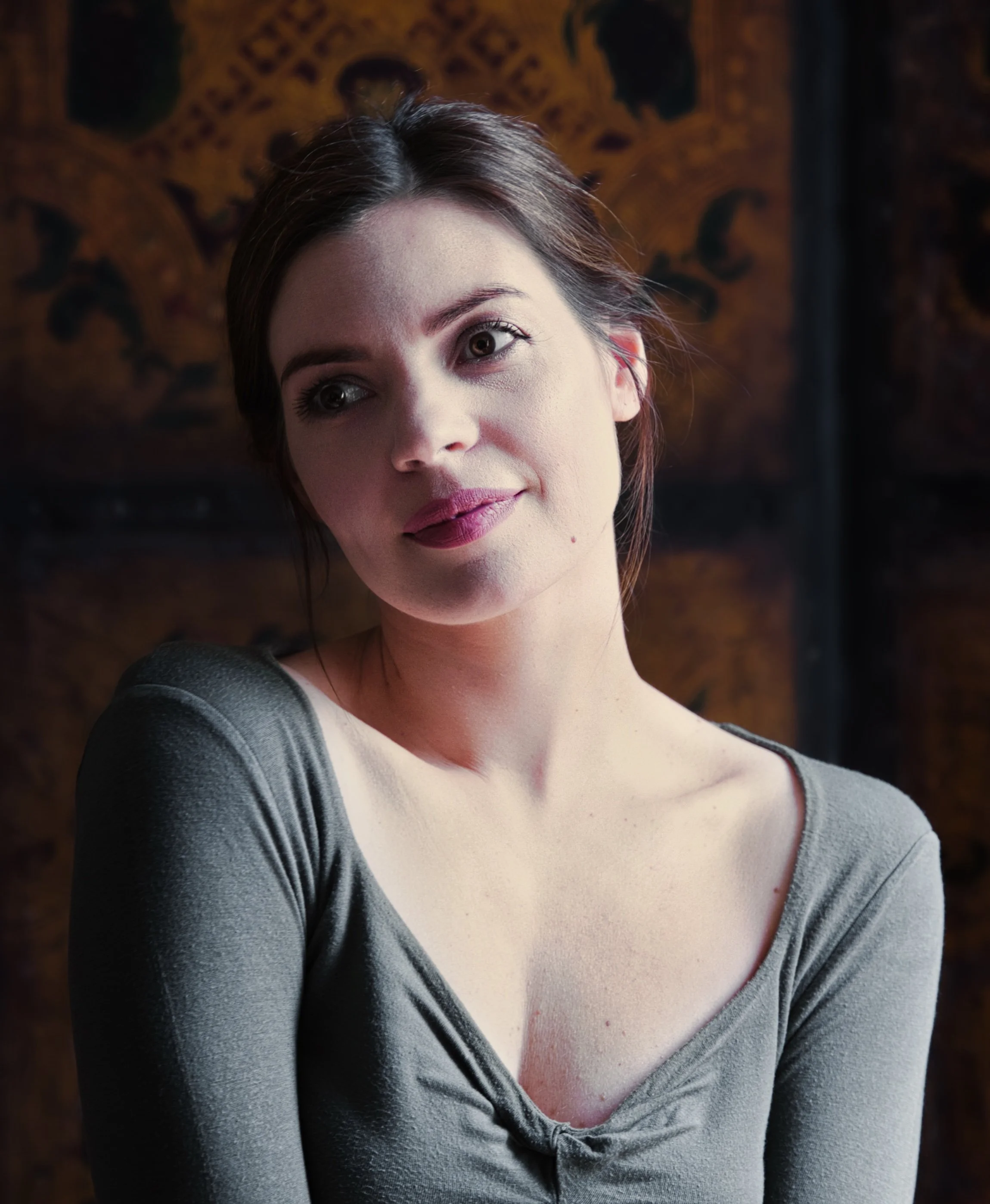 Portrait of a woman in warm natural light with patterned background