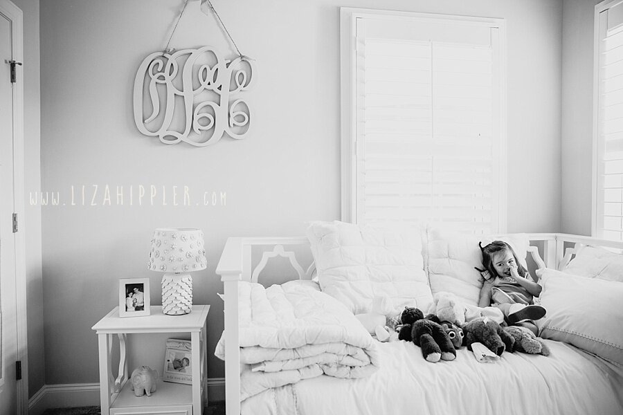 black and white image of toddler girl in her beautiful bedroom
