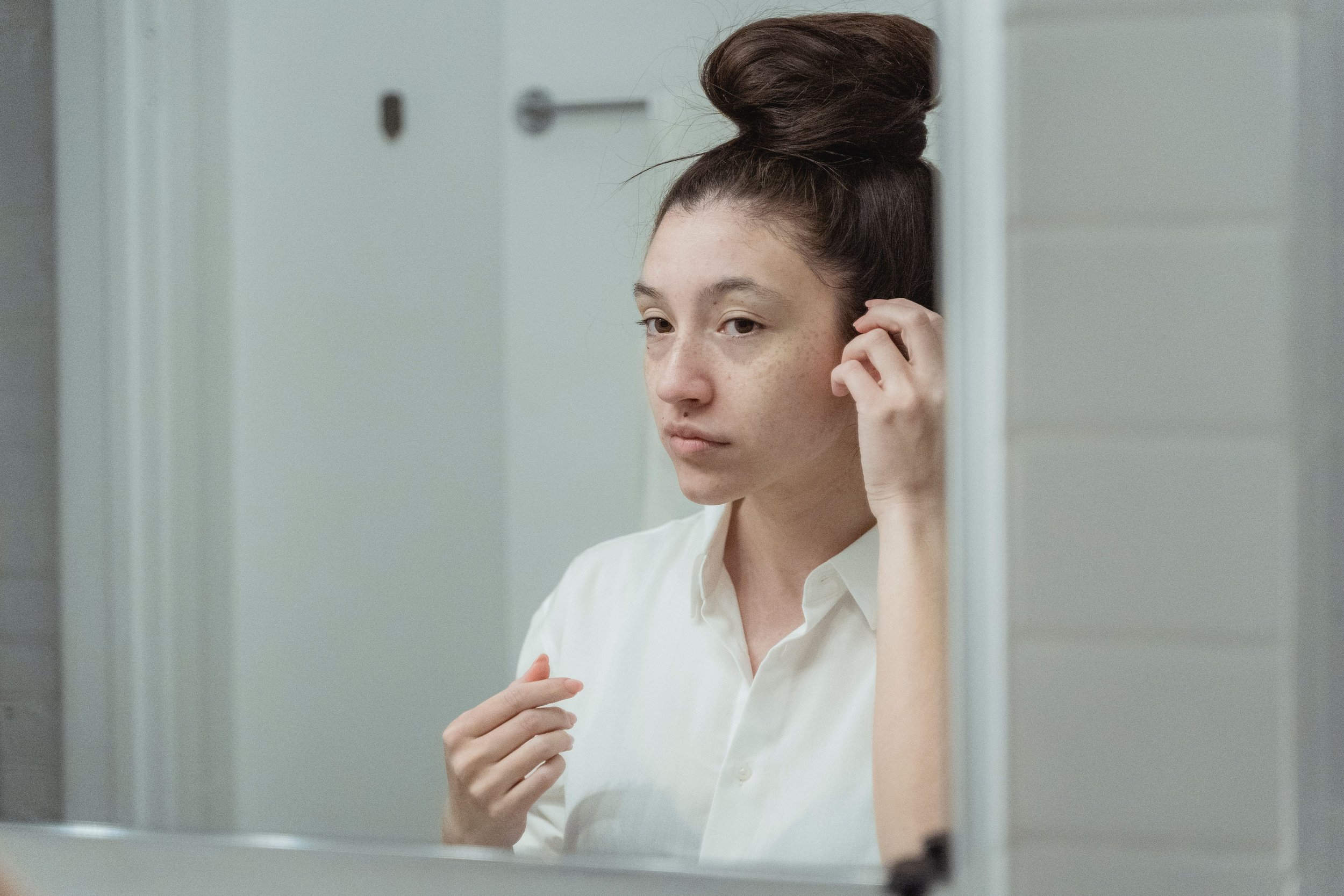 Woman Reflecting in the mirror avoiding negative self talk
