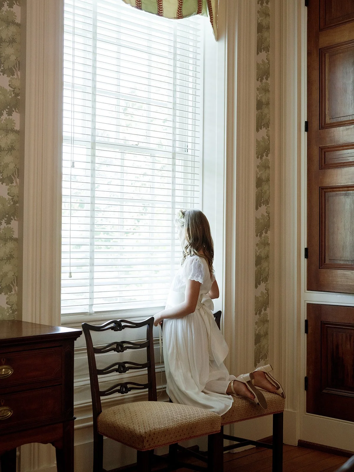 Flower girl peering out to designer kentucky wedding ceremony