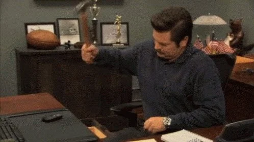 Ron Swanson destroying a phone with a hammer