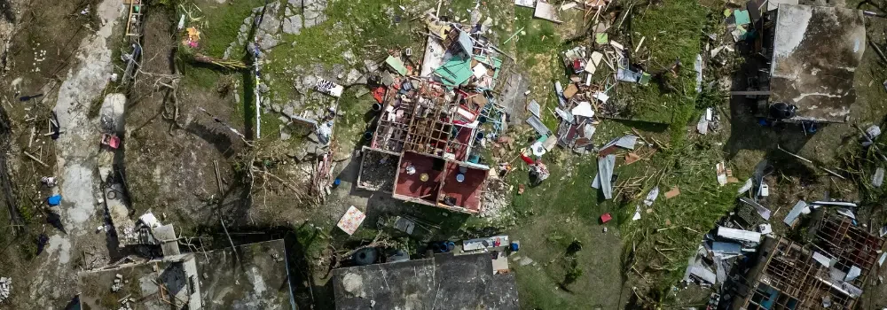 Aerial view of a Louisiana neighborhood devastated by a hurricane, with destroyed homes and scattered debris