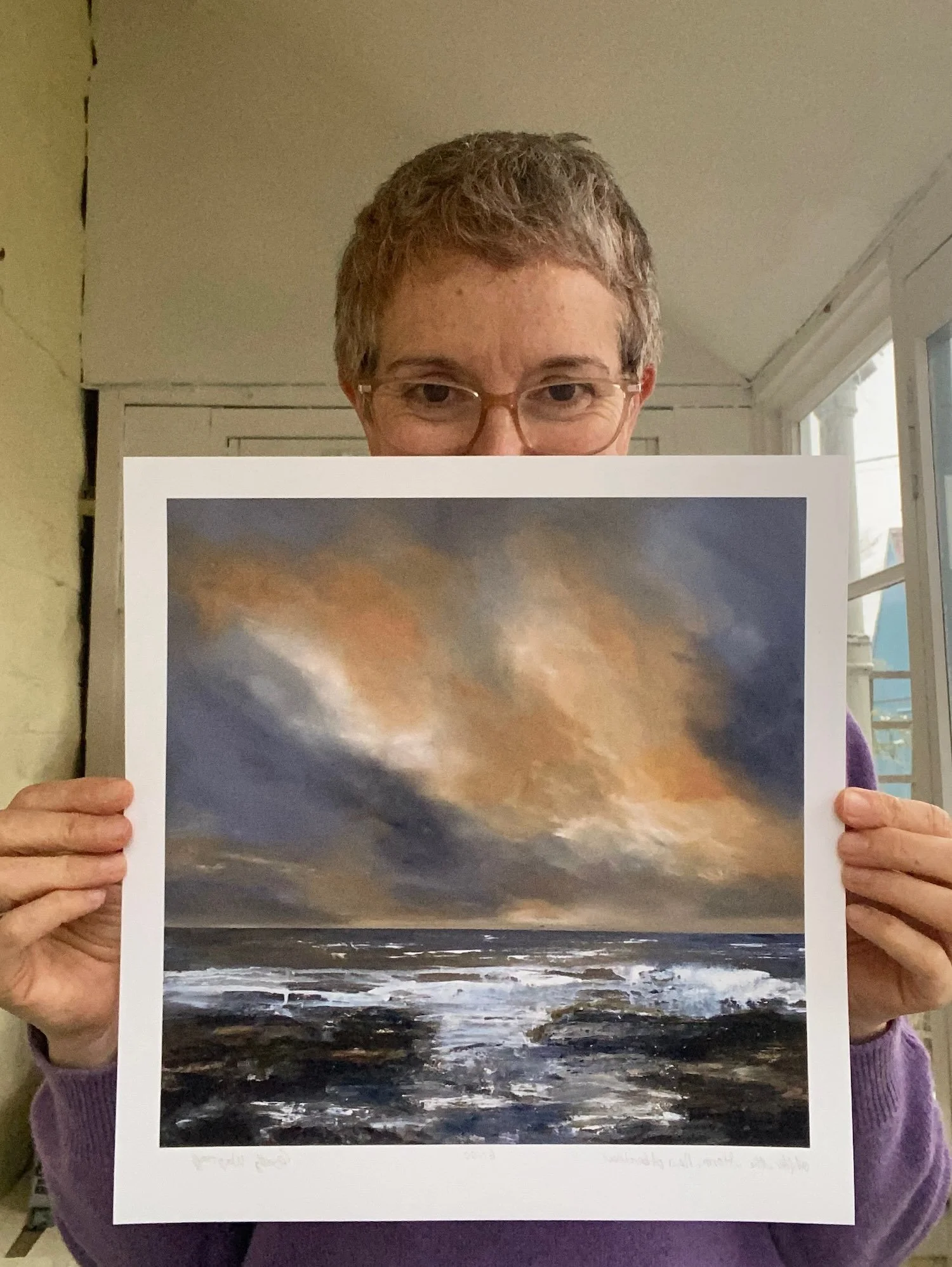 cathy-wagstaff-artist holding after-storm-giclee print, orange clouds in blue sky distant horizon white waves on beach