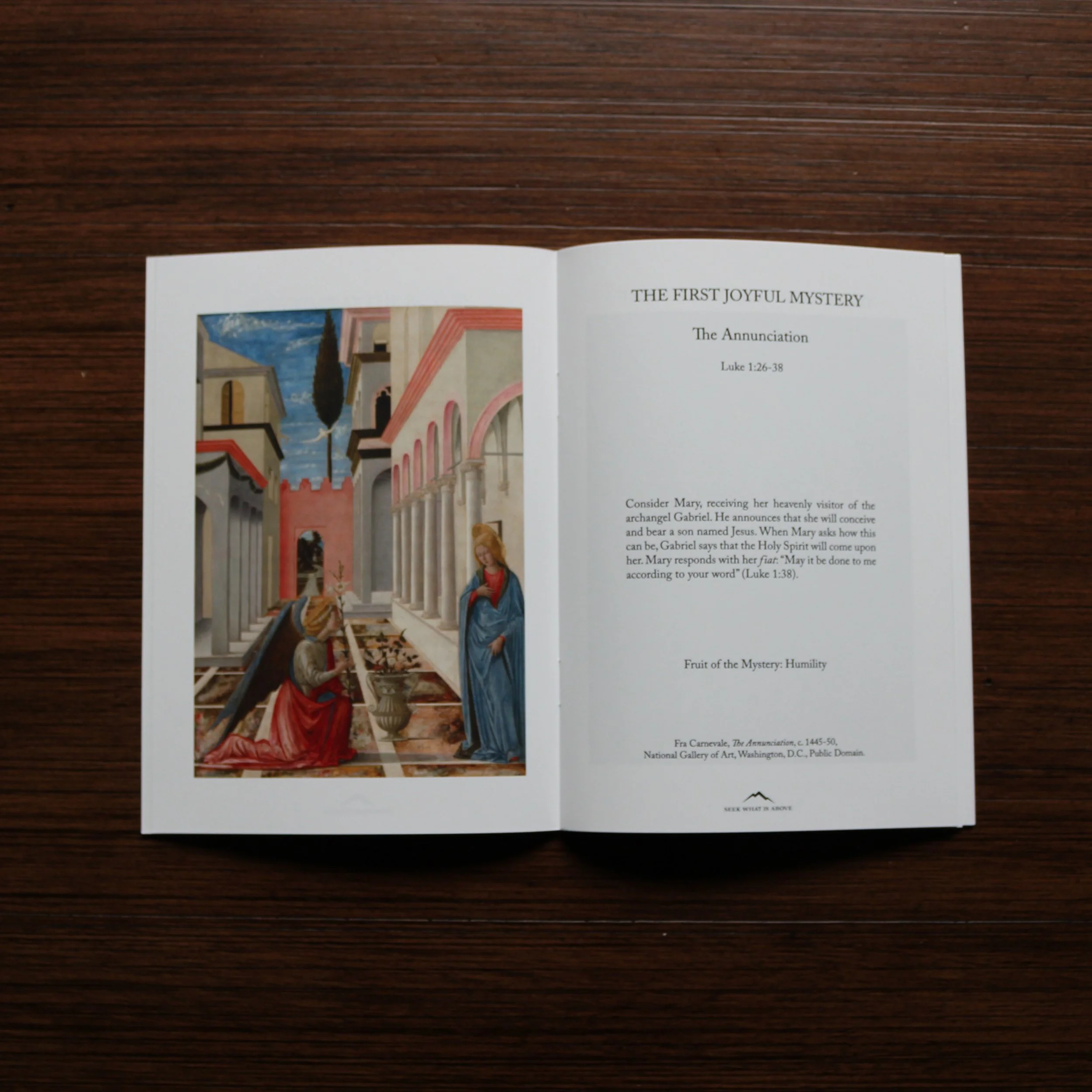 Catholic Rosary book open to Annunciation Mystery featuring sacred art painting and meditation