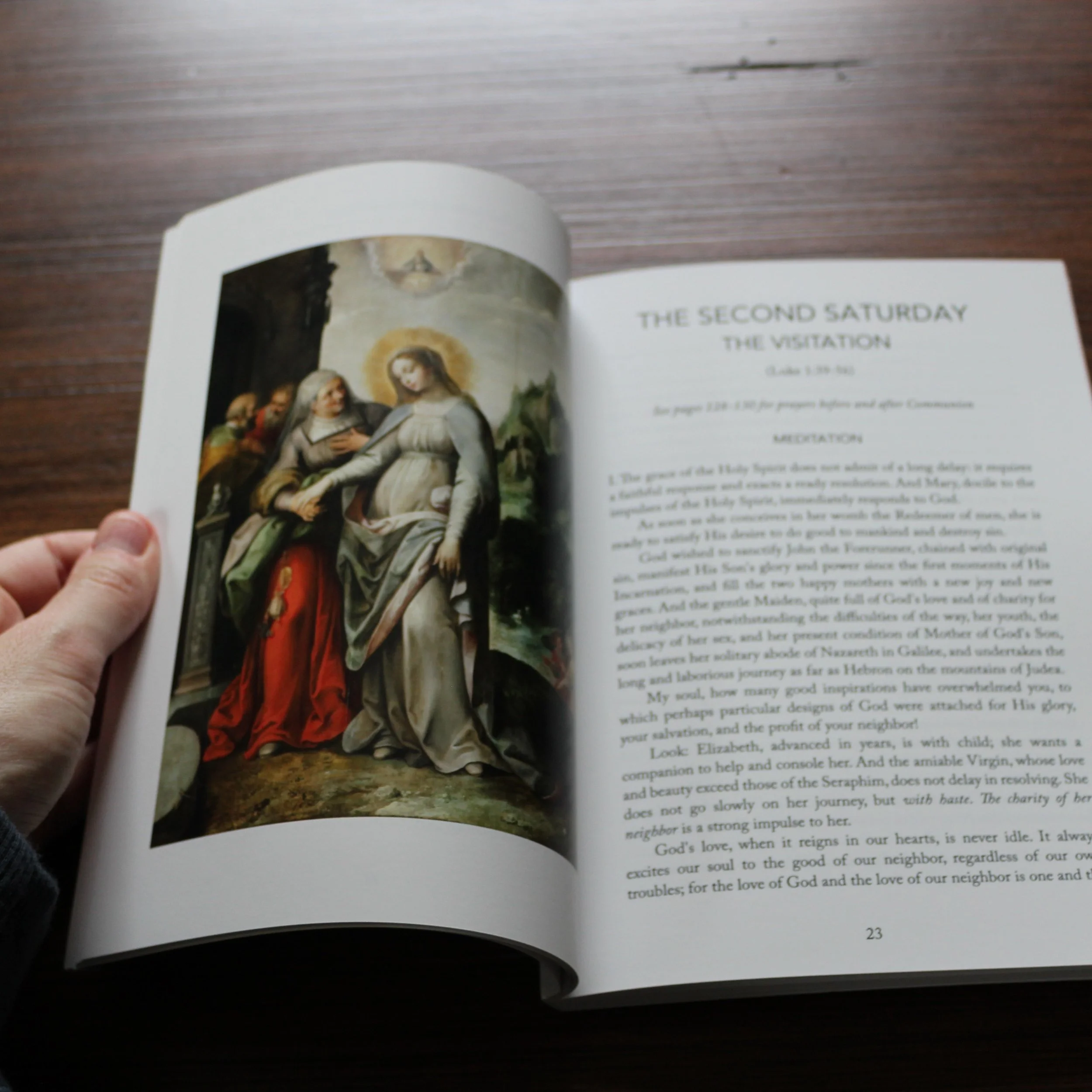 The Fifteen Saturdays book opened to the Visitation meditation and sacred painting