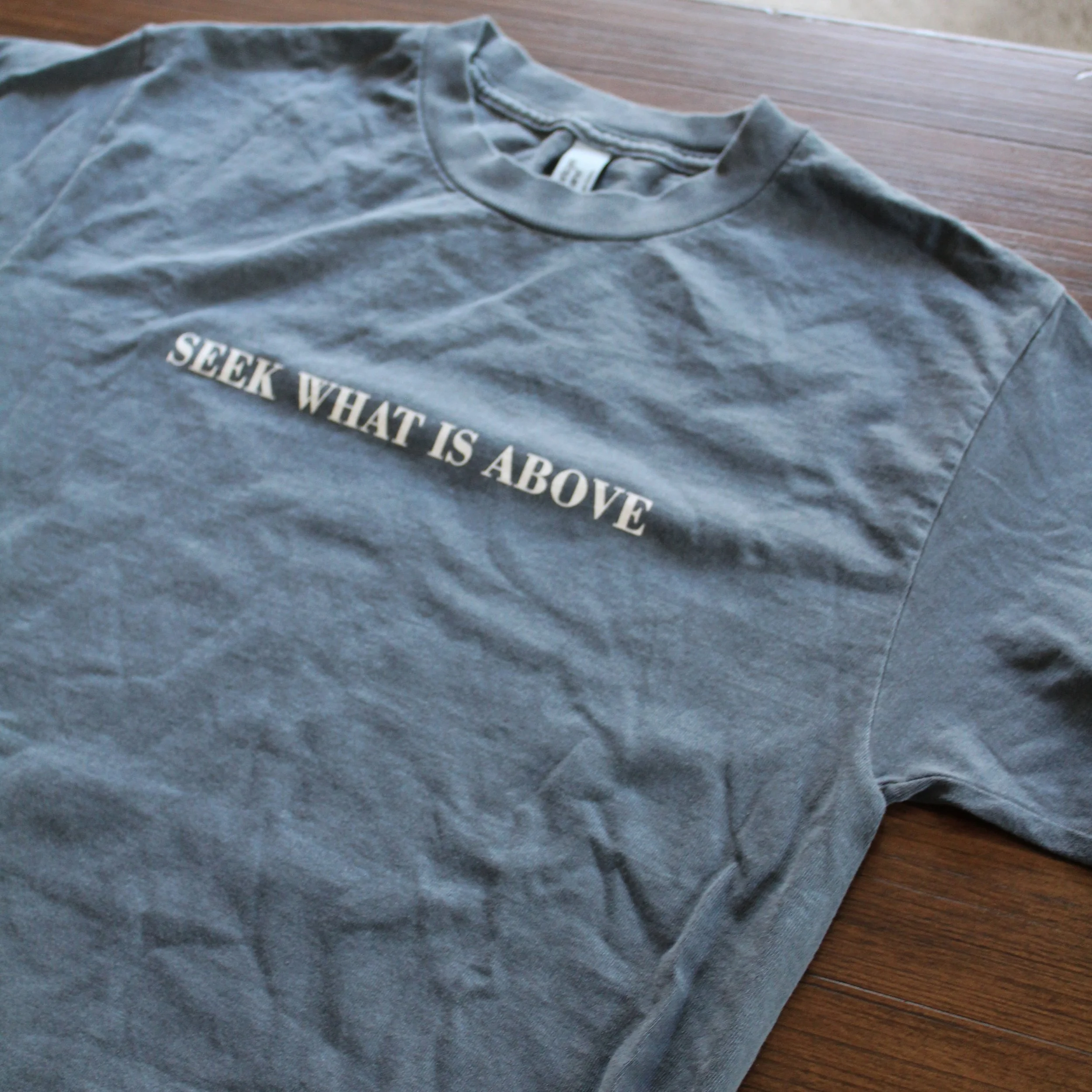 Blue “Seek What Is Above” Christian t-shirt with minimalist white text