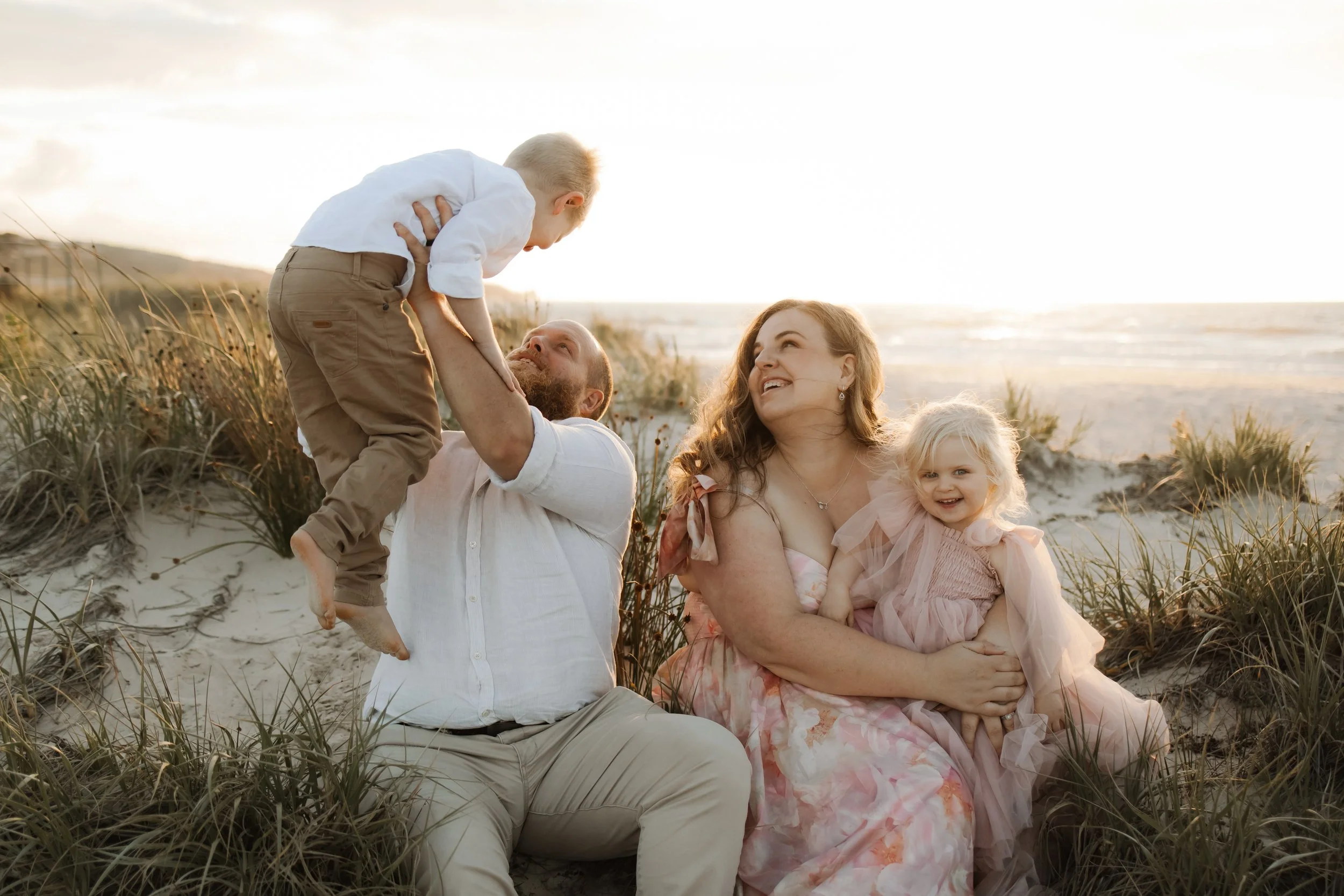 dreamy beach family photoshoot southern Adelaide beach family wearing soft pinks and cream coloured outfits photos natural and candid and fun