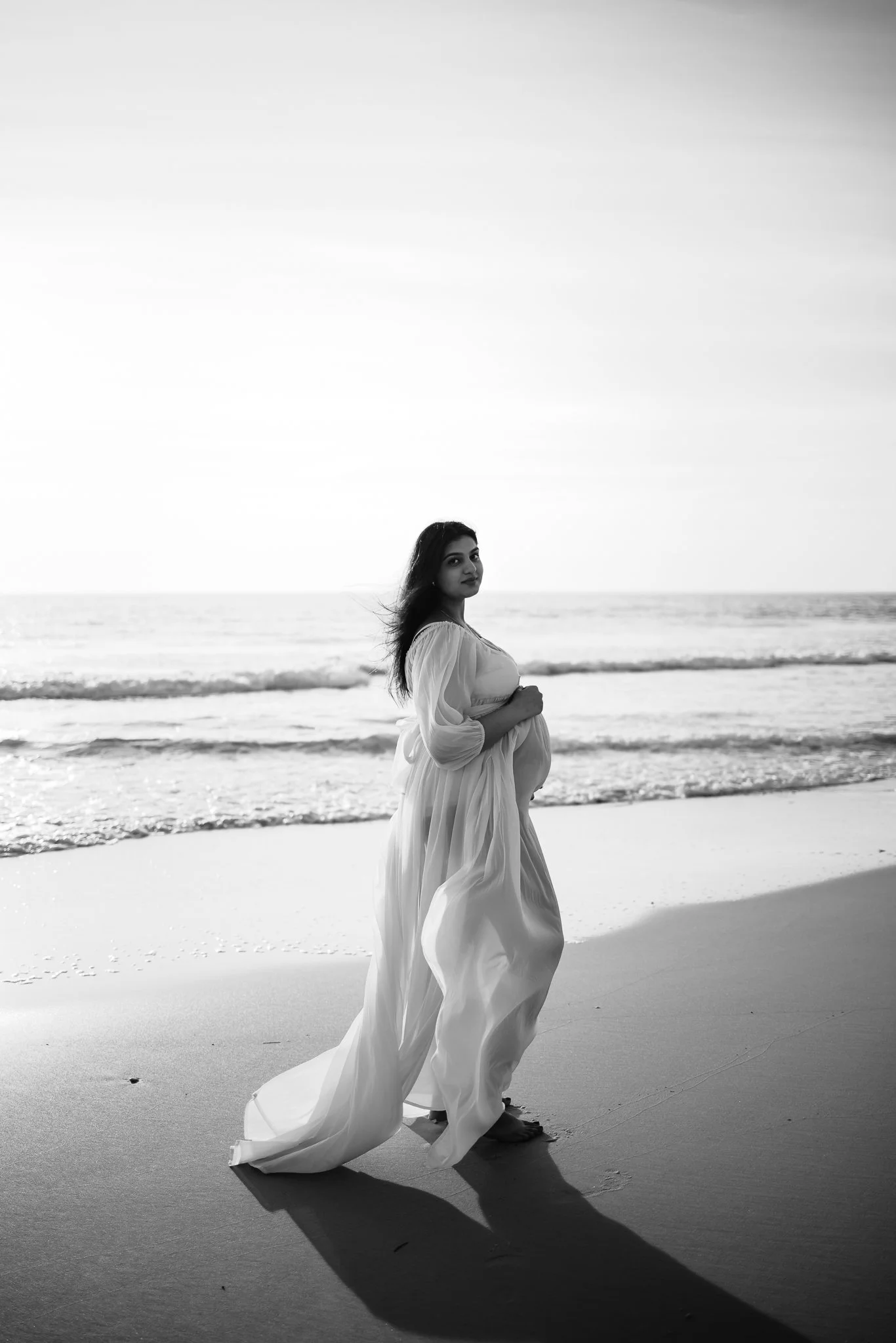 black and white photos of pregnant women in flowing dress on an Adelaide beach.
