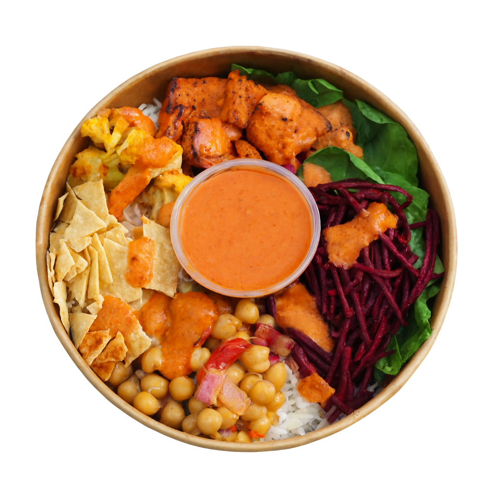 Salad box with roasted sweet potatoes, mushrooms, shredded beets, chopped onions, tomatoes, kale, chickpeas, almond slivers, and a container of dressing in the center.