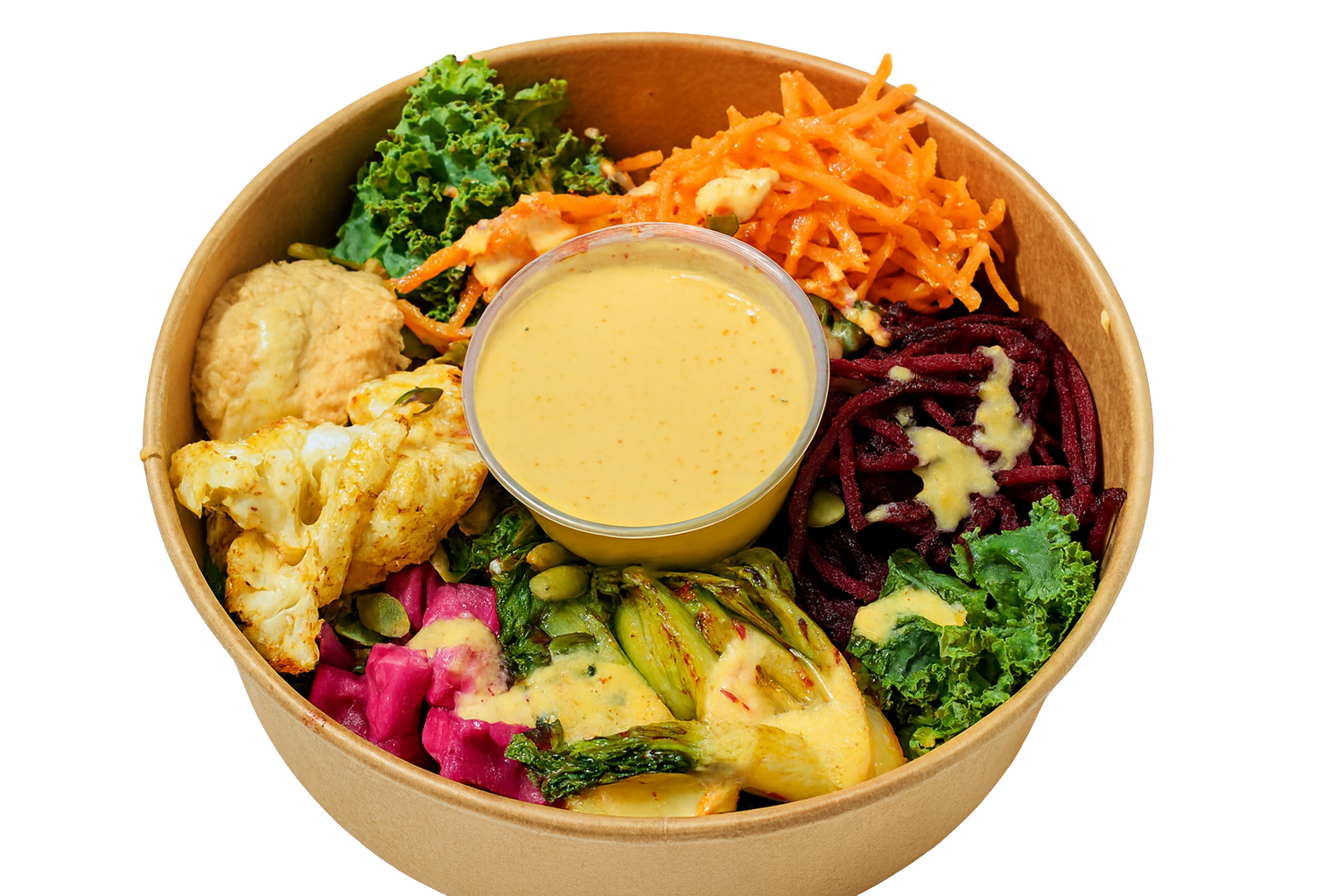 Box with a variety of vegetables including roasted cauliflower, shredded beets, diced onions, kale, spinach, shredded carrots, pumpkin seeds, and corn, with hummus and a cup of dressing.