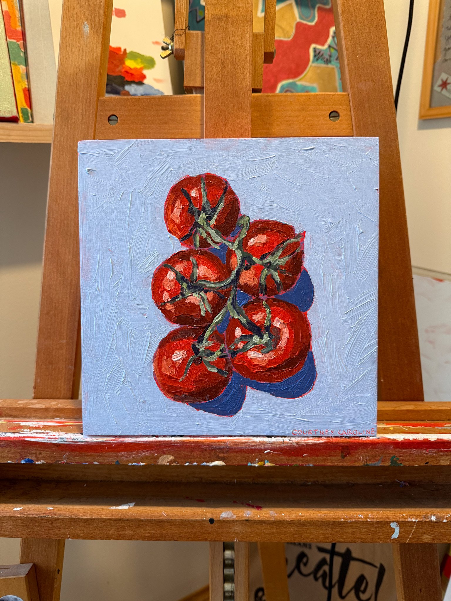 Acrylic painting of five tomatoes on a vine on wood panel by Courtney Caroline